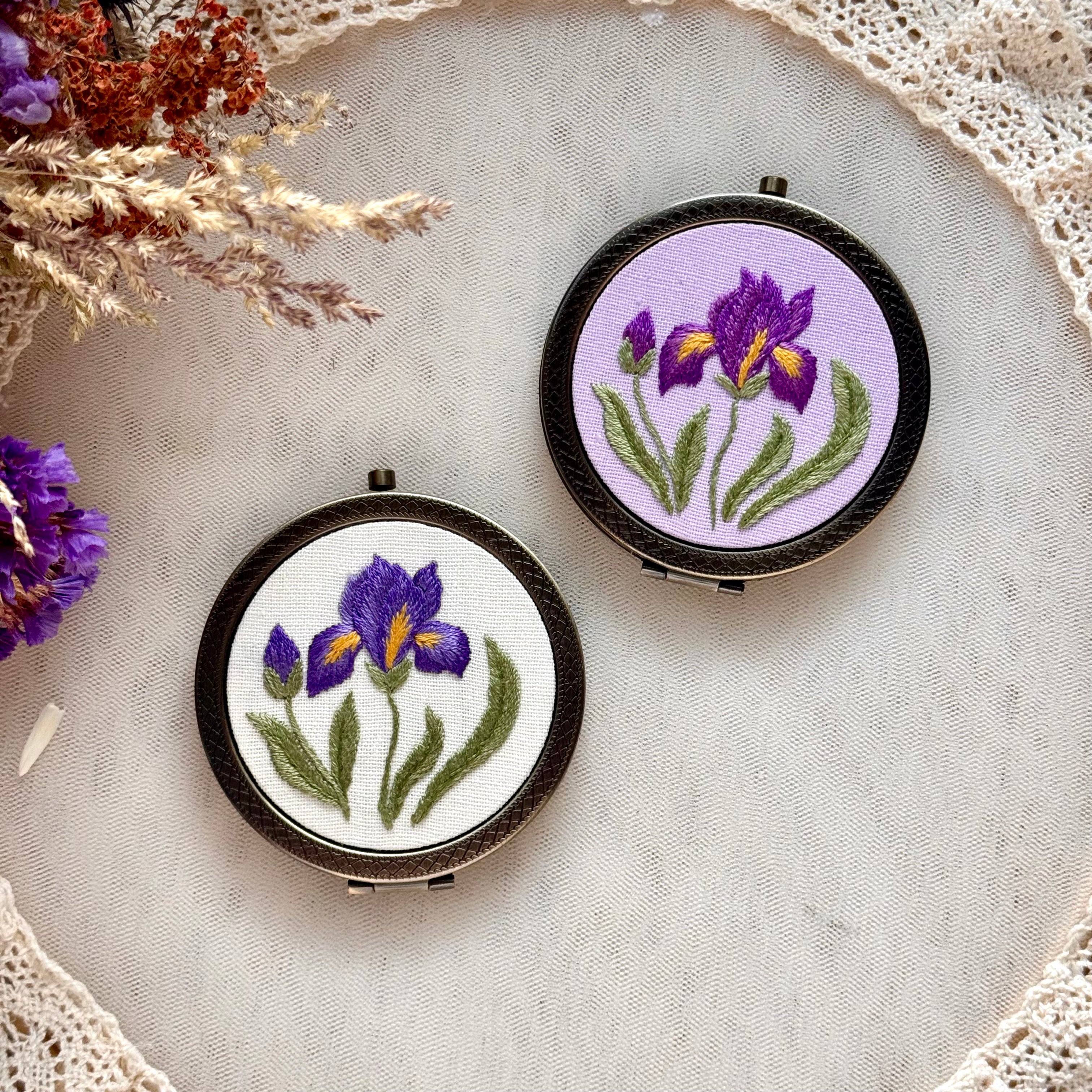 Käsin kirjottu taskupeili, etelänkurjenmiekka-aiheinen kuvio kannessa