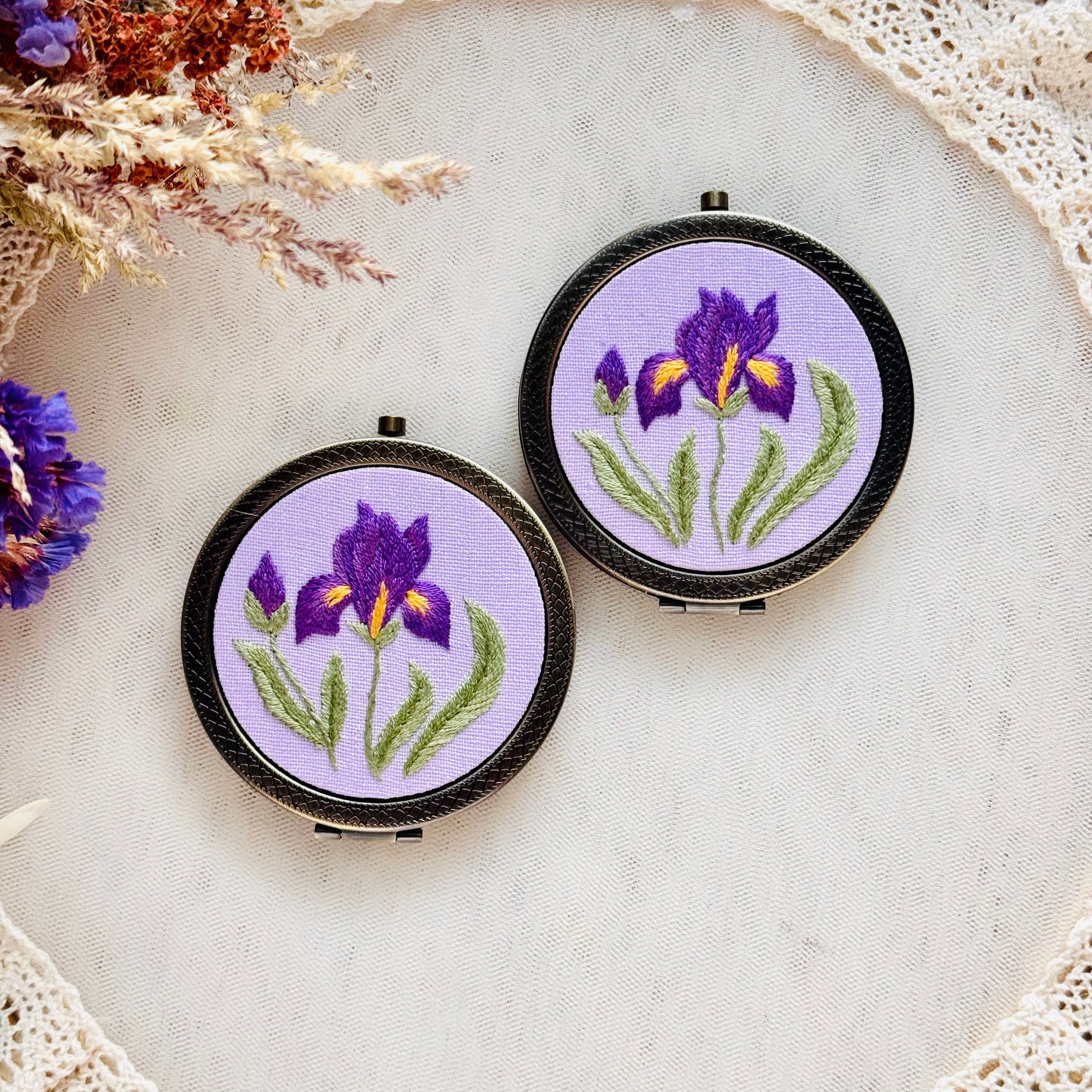 Käsin kirjottu taskupeili, etelänkurjenmiekka-aiheinen kuvio kannessa