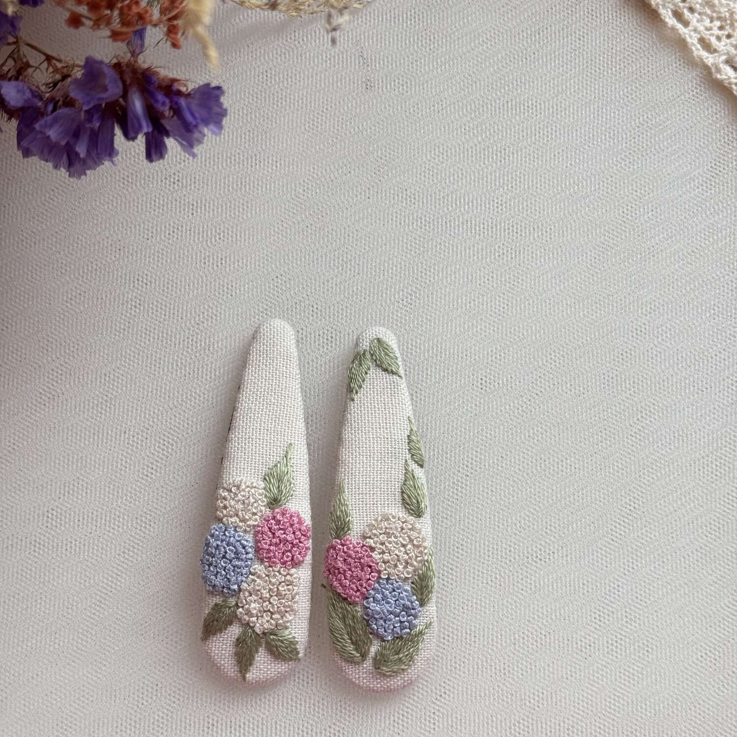 Käsin kirjotut hiuspinnit, hortensiakimppu-aiheinen kuvio kankaalla