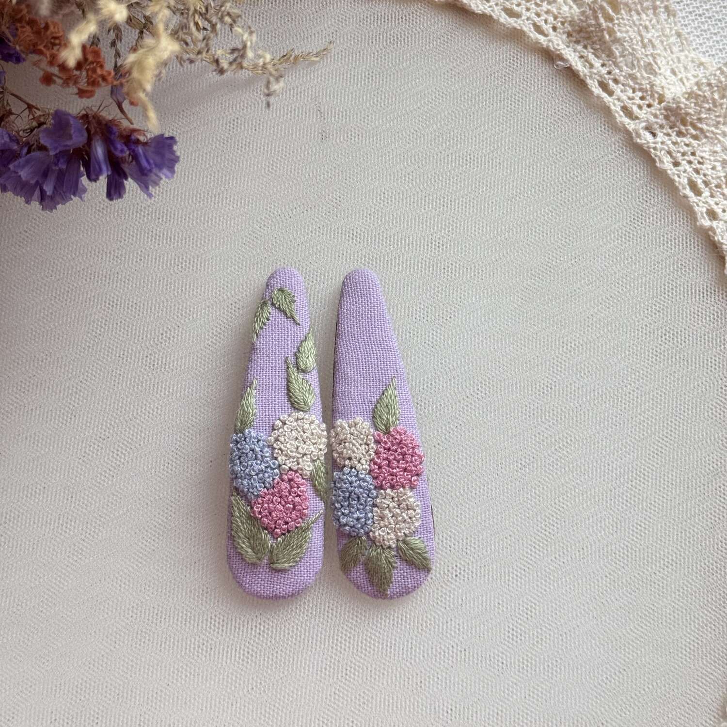 Käsin kirjotut hiuspinnit, hortensiakimppu-aiheinen kuvio kankaalla