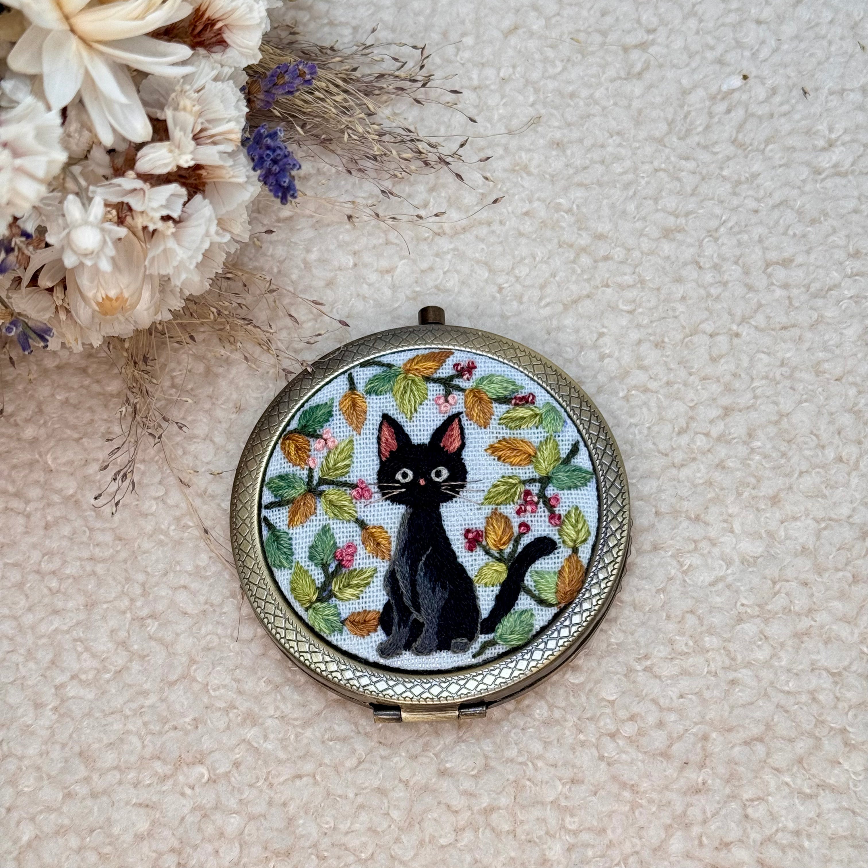 Käsin kirjottu taskupeili, Jiji kissa -aiheinen kuvio kannessa