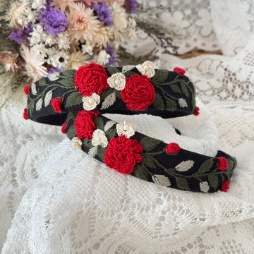 Two floral-patterned headbands with red and white flowers on a lace background.