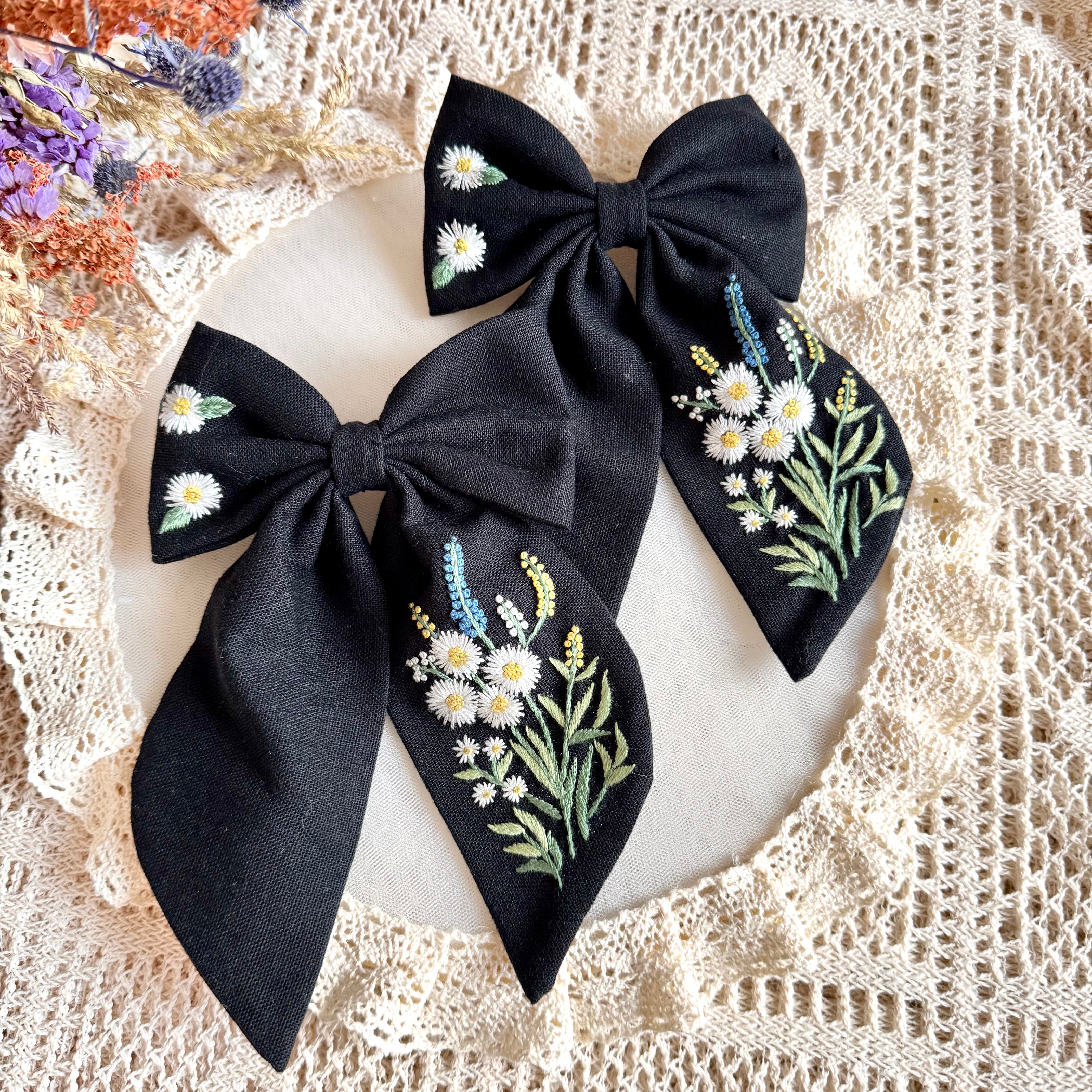 Käsin kirjottu hiusrusetti, kaunokainen-aiheinen kuvio kankaalla