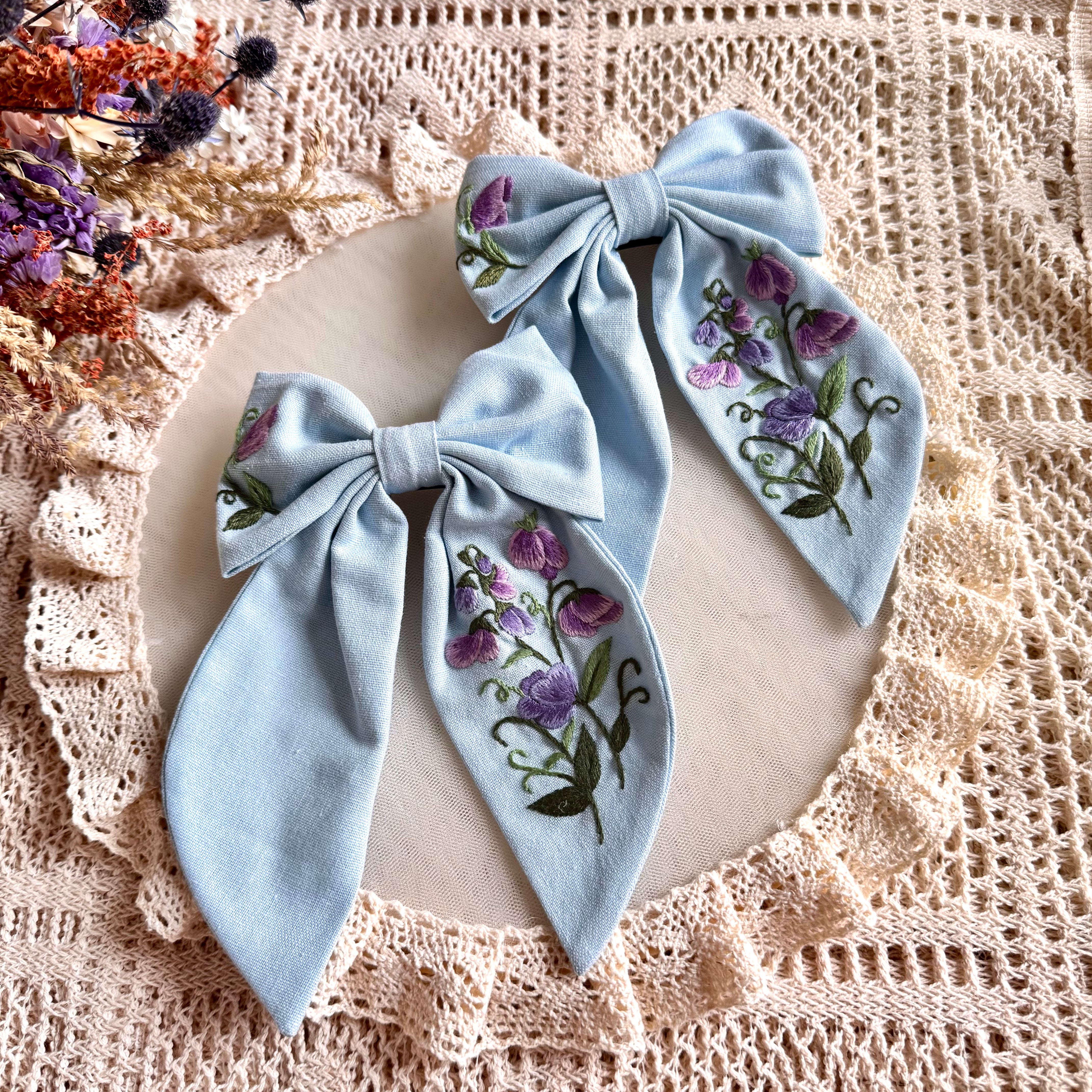 Käsin kirjottu hiusrusetti, kevätlinnunherne-aiheinen kuvio kankaalla