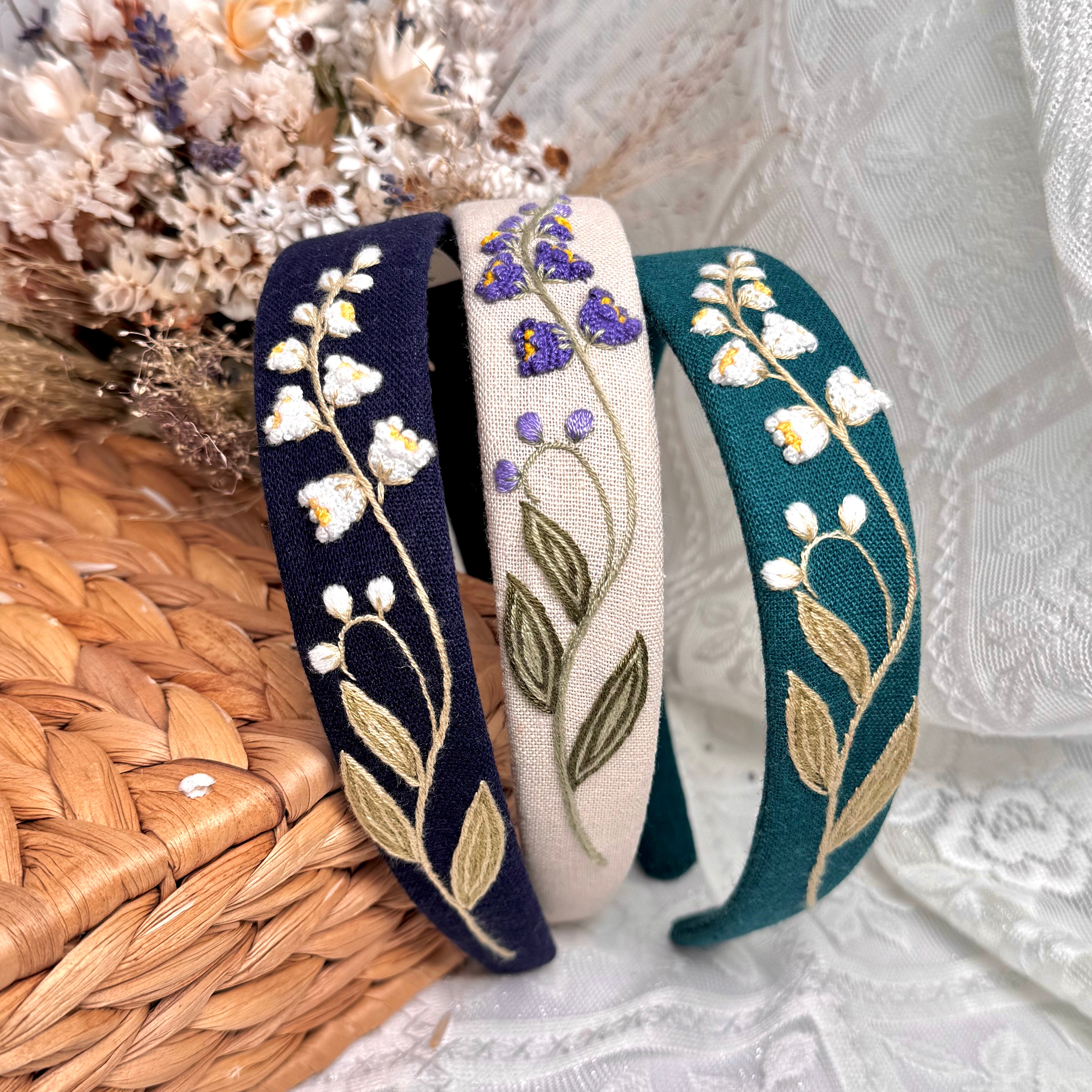 Käsin kirjottu hiuspanta, kielo-aiheinen kuvio kankaalla