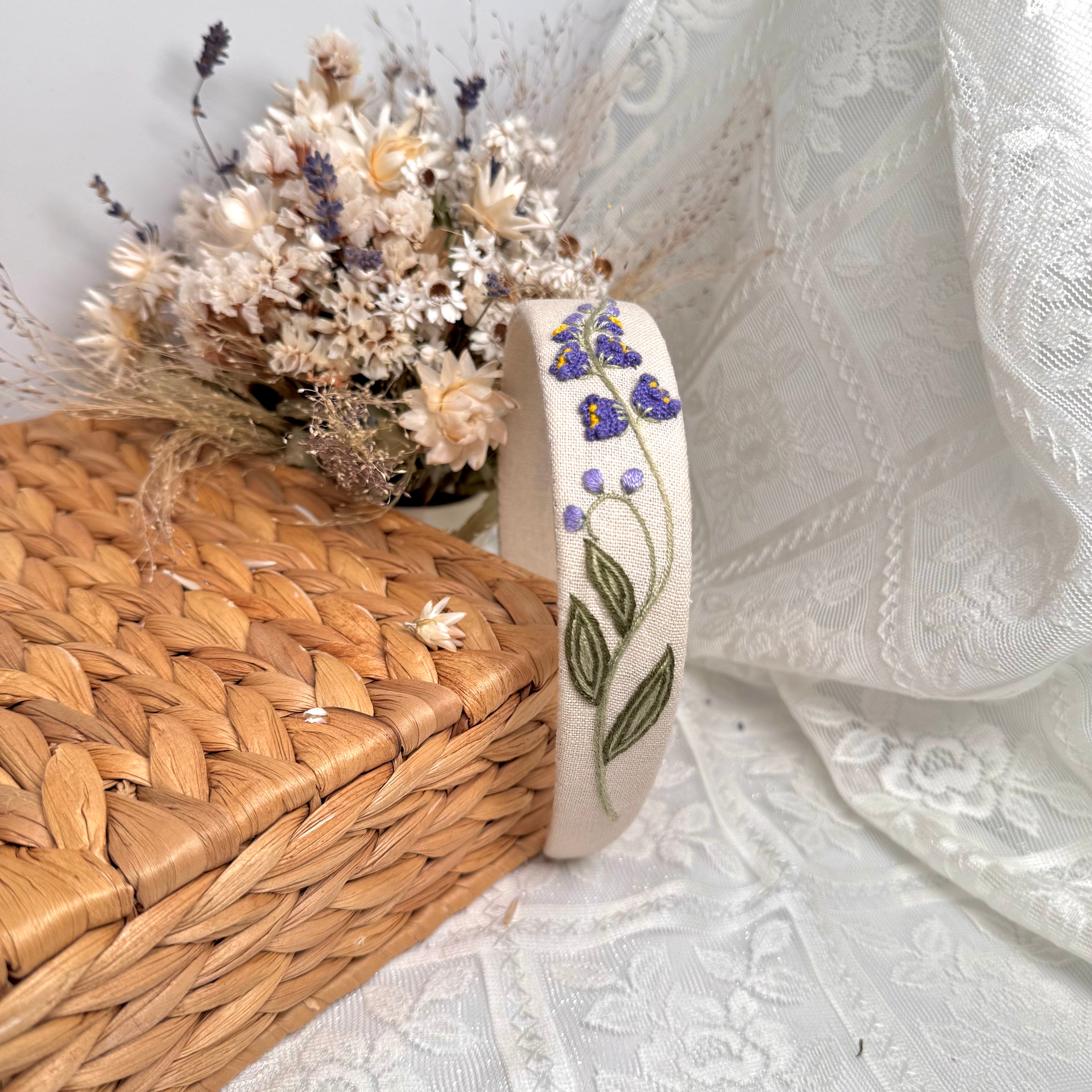 Käsin kirjottu hiuspanta, kielo-aiheinen kuvio kankaalla