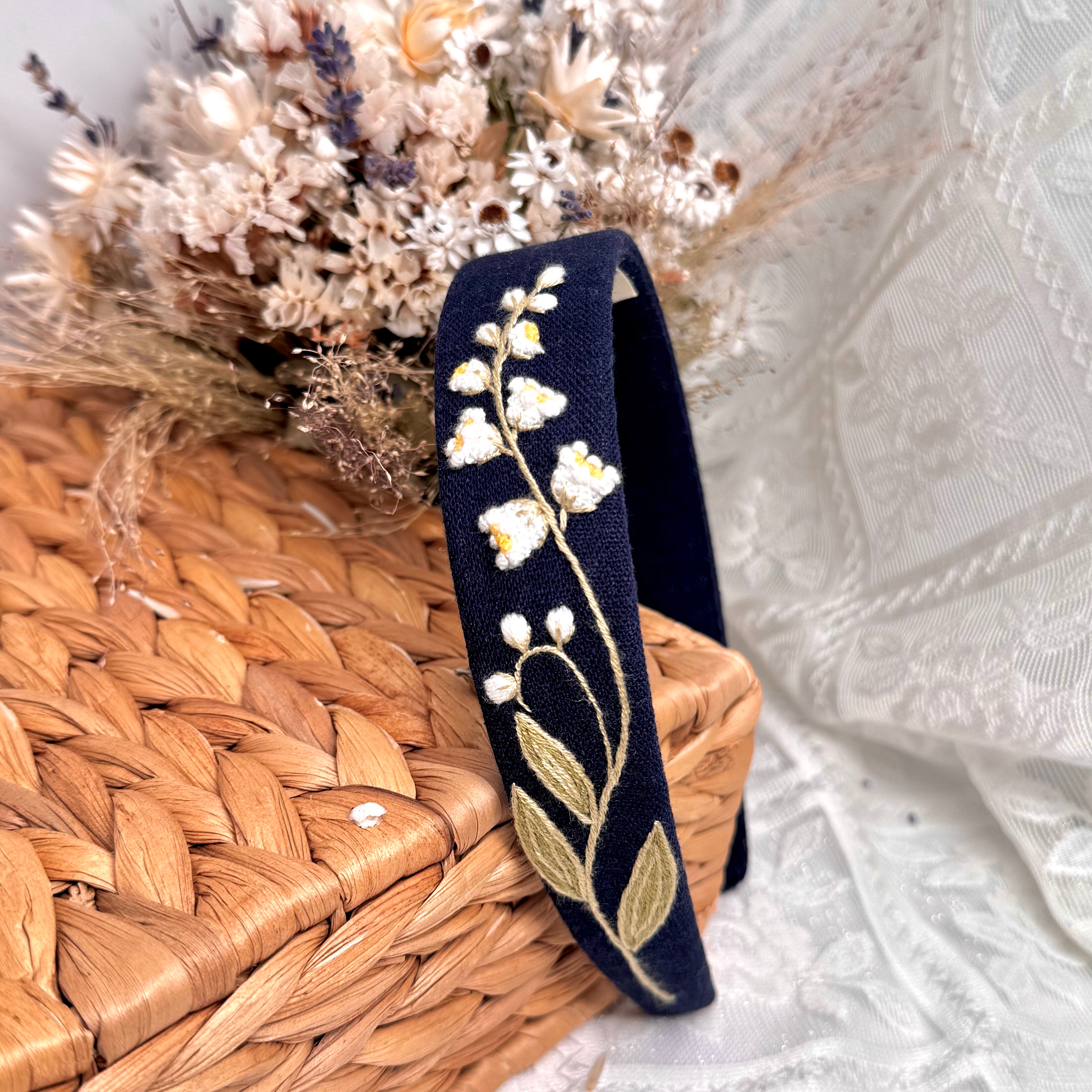 Käsin kirjottu hiuspanta, kielo-aiheinen kuvio kankaalla