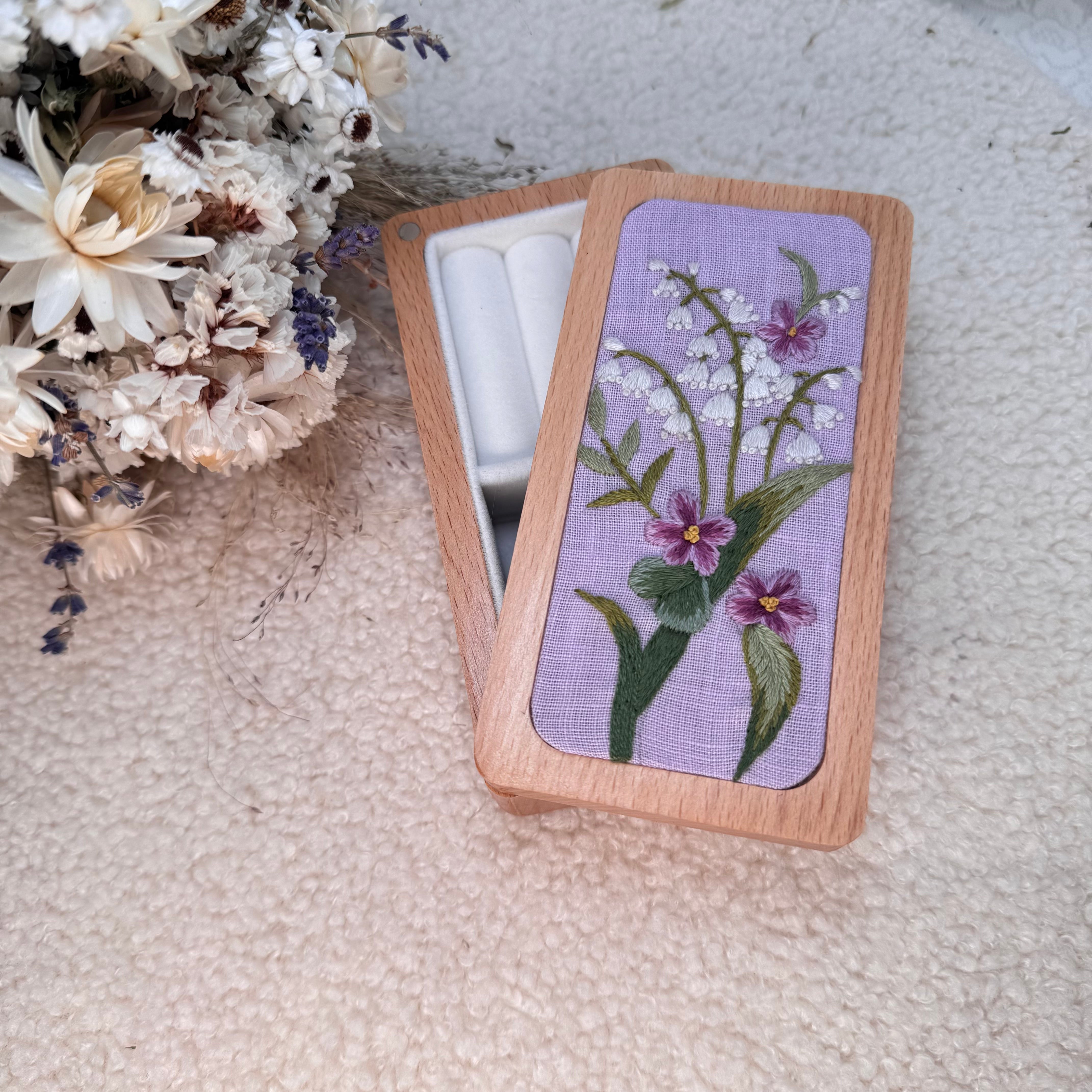 Puinen korurasia, käsin kirjottu kielo ja luhtalemikki kukkakuvio