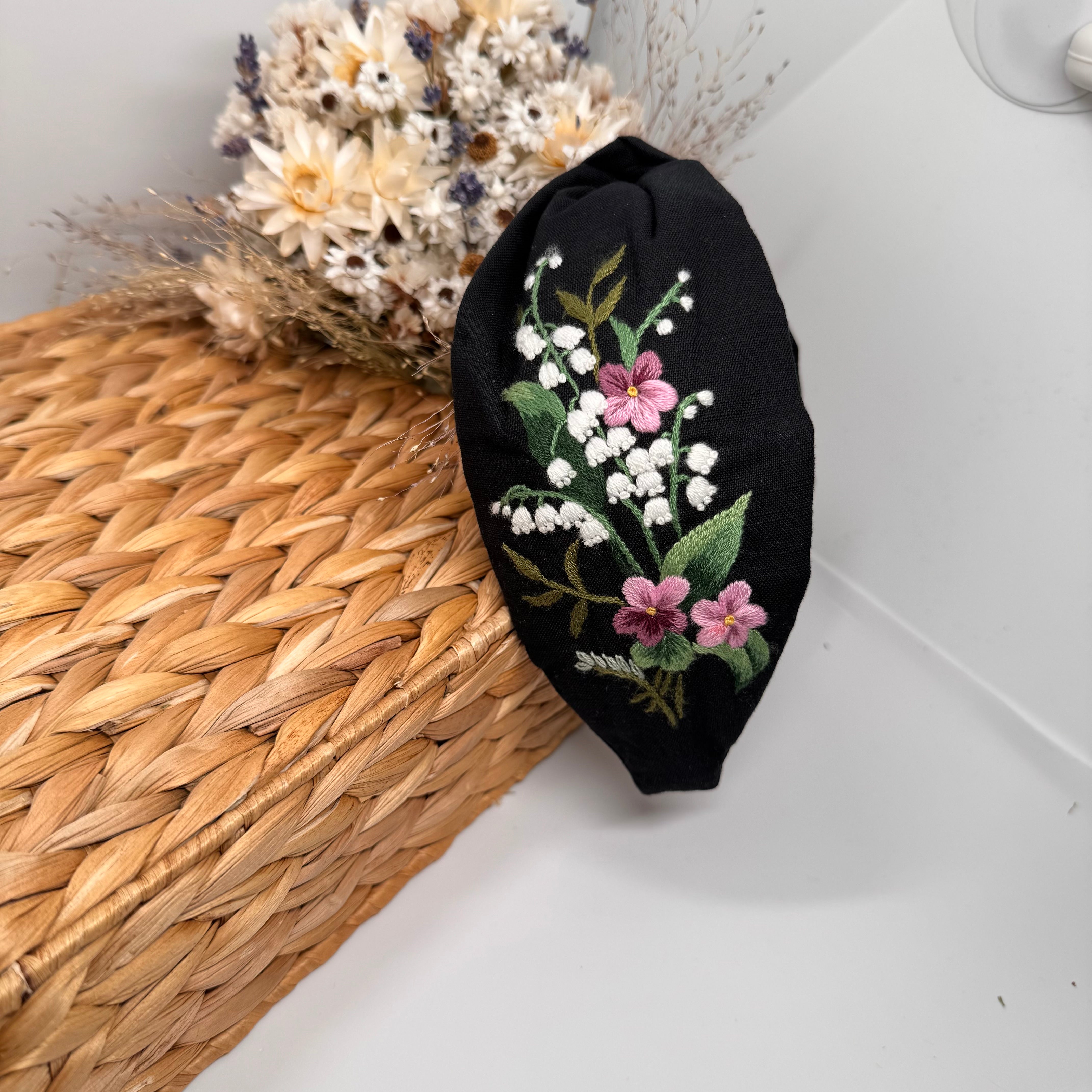 Käsin kirjottu turbaanipanta, kielo ja luhtalemmikki -aiheinen kuvio kankaalla