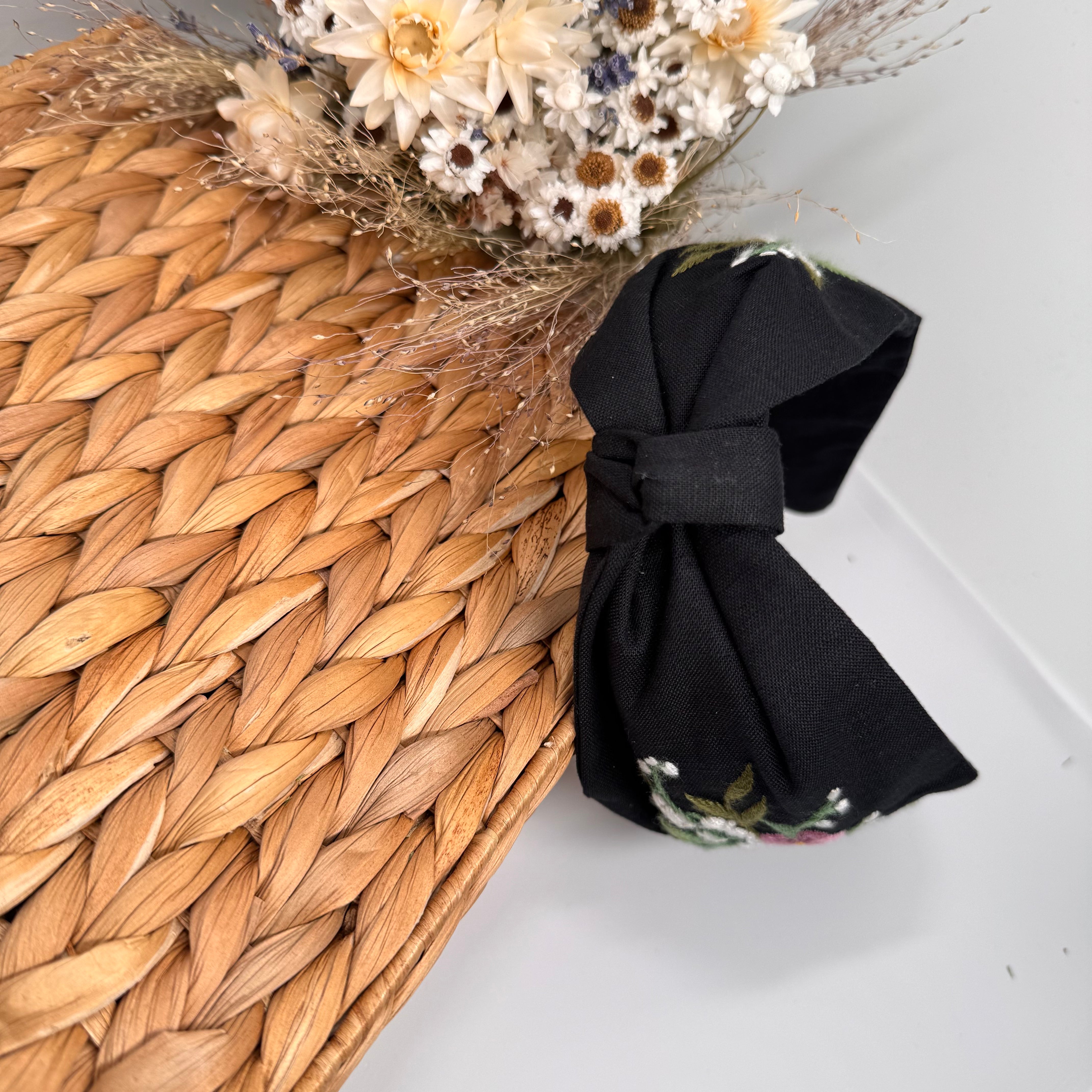 Käsin kirjottu turbaanipanta, kielo ja luhtalemmikki -aiheinen kuvio kankaalla