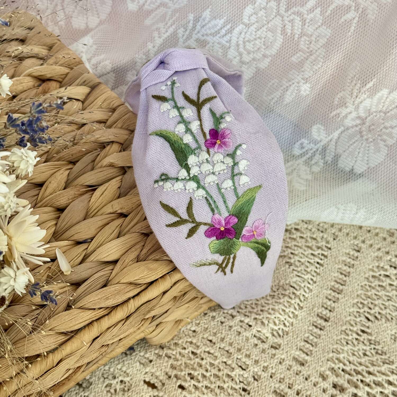 Käsin kirjottu turbaanipanta, kielo ja luhtalemmikki -aiheinen kuvio kankaalla