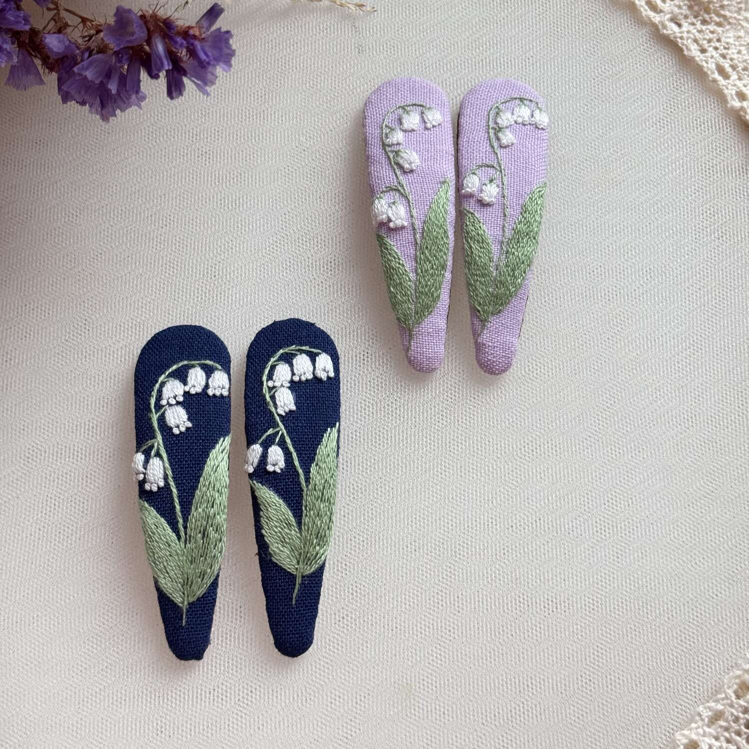 Käsin kirjotut hiuspinnit, kielo-aiheinen kuvio kankaalla