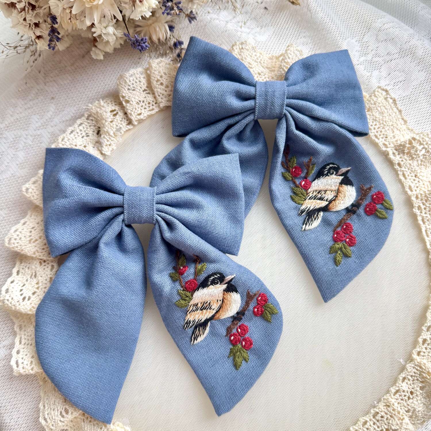 Käsin kirjottu hiusrusetti, kuusitiainen ja pihlaja -aiheinen kuvio kankaalla