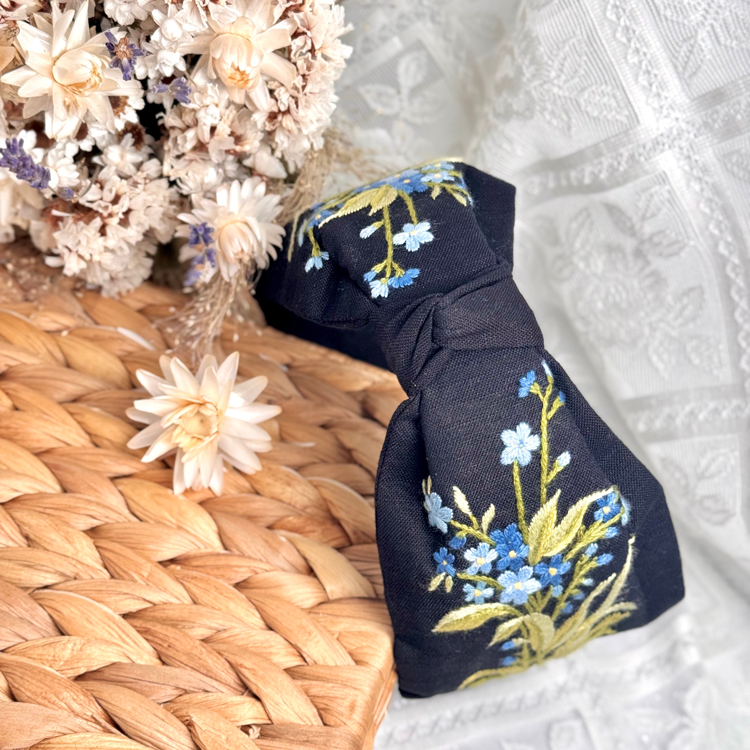 Käsin kirjottu turbaanipanta, luhtalemmikki-aiheinen kuvio kankaalla