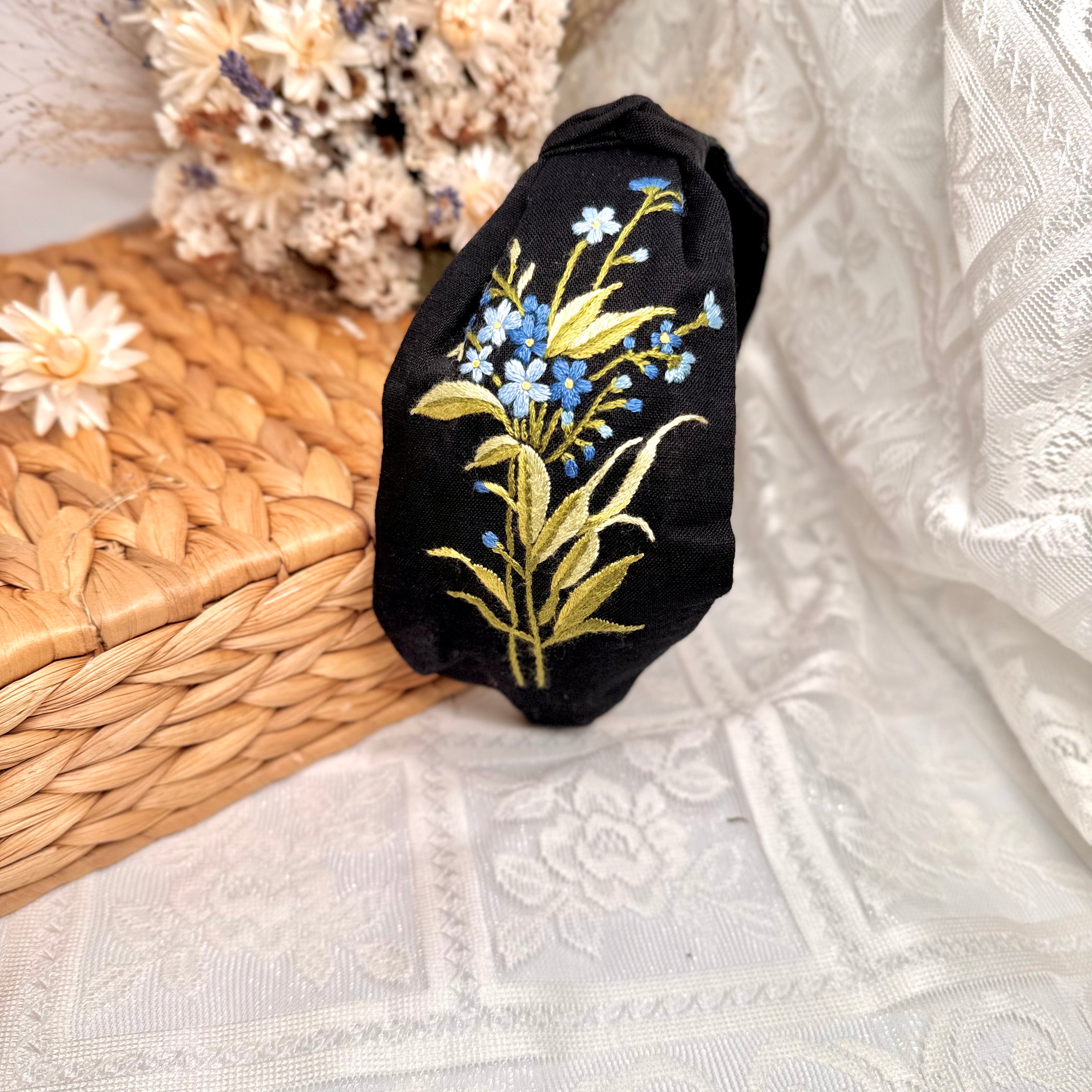 Käsin kirjottu turbaanipanta, luhtalemmikki-aiheinen kuvio kankaalla