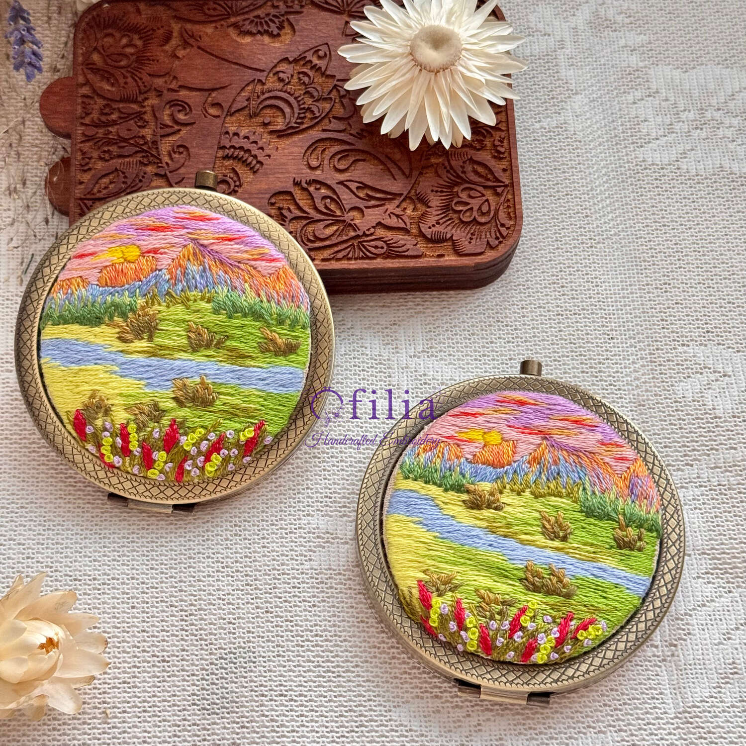 Käsinkirjailtu lumihuiput ja vihreä niitty maisemataskupeili – Ofilia Handmade