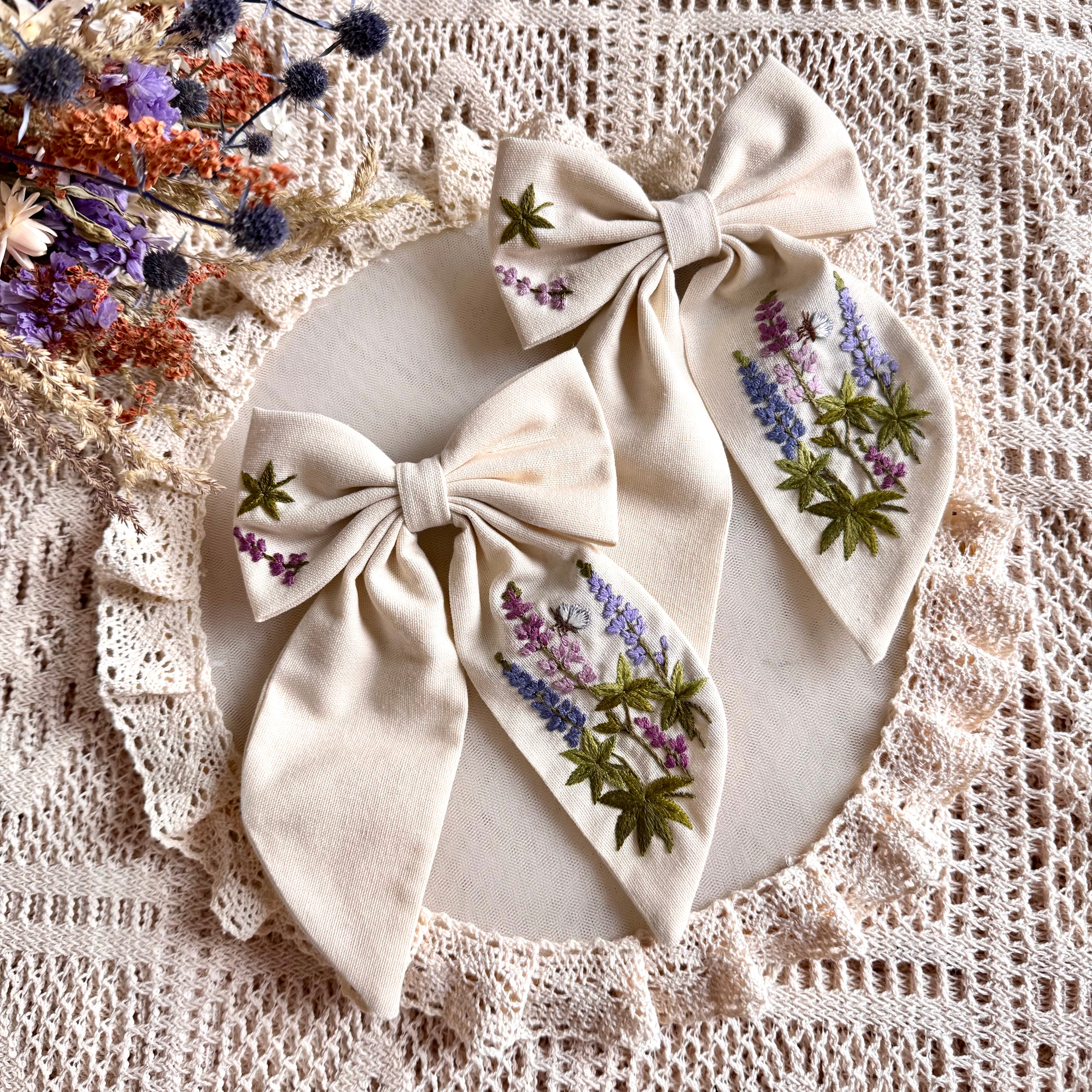 Käsin kirjottu hiusrusetti, lupiini-aiheinen kuvio kankaalla