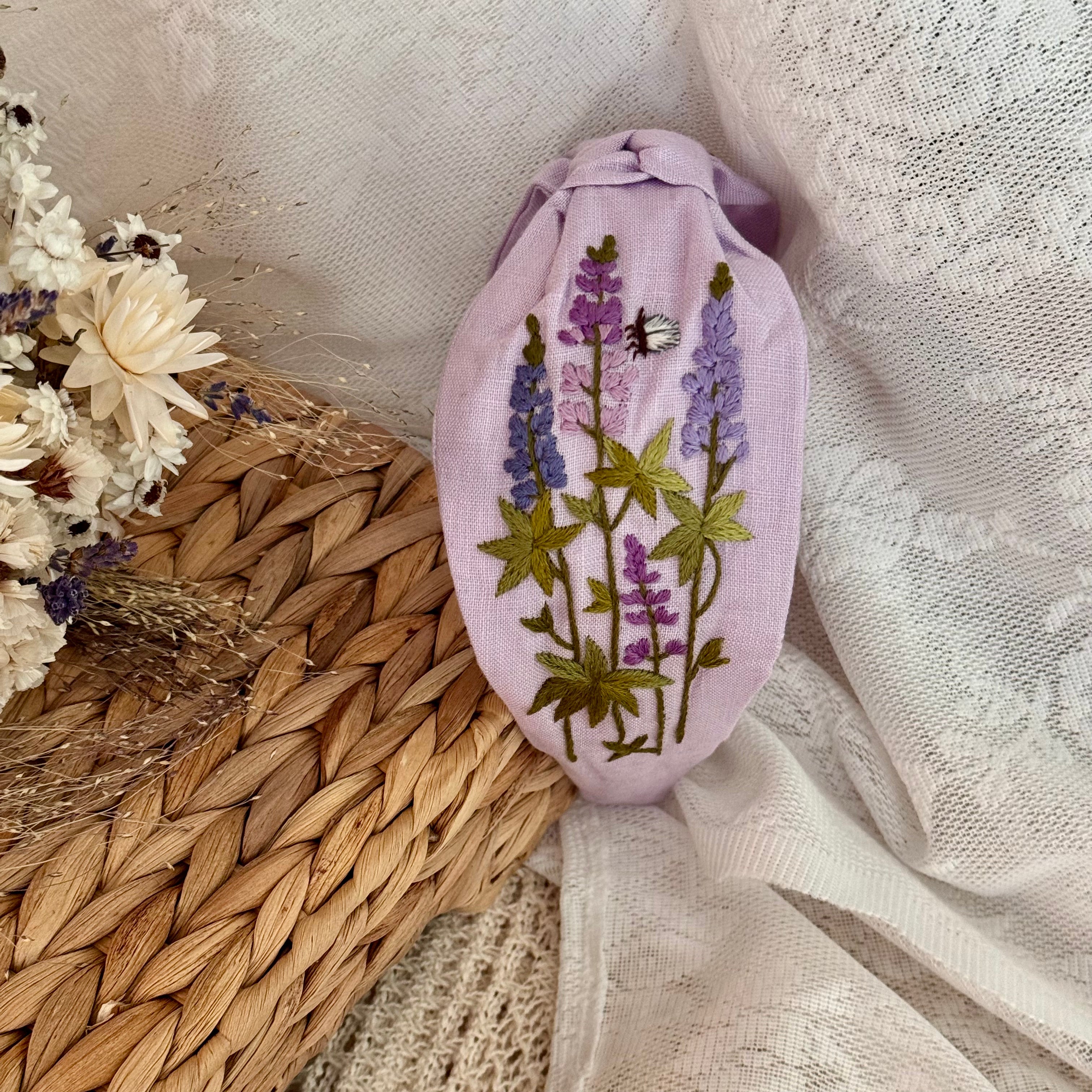 Käsin kirjottu turbaanipanta, lupiini-aiheinen kuvio kankaalla