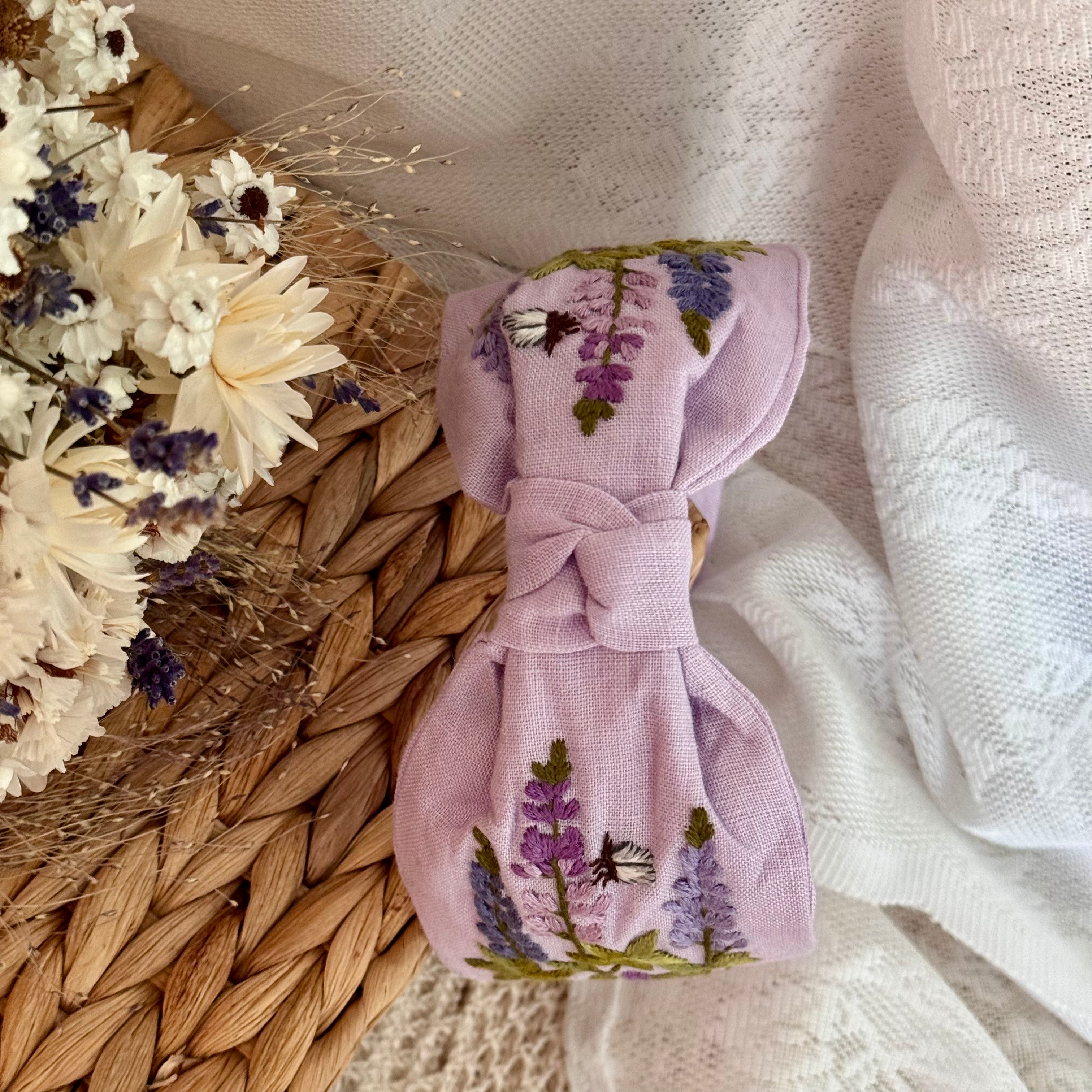 Käsin kirjottu turbaanipanta, lupiini-aiheinen kuvio kankaalla