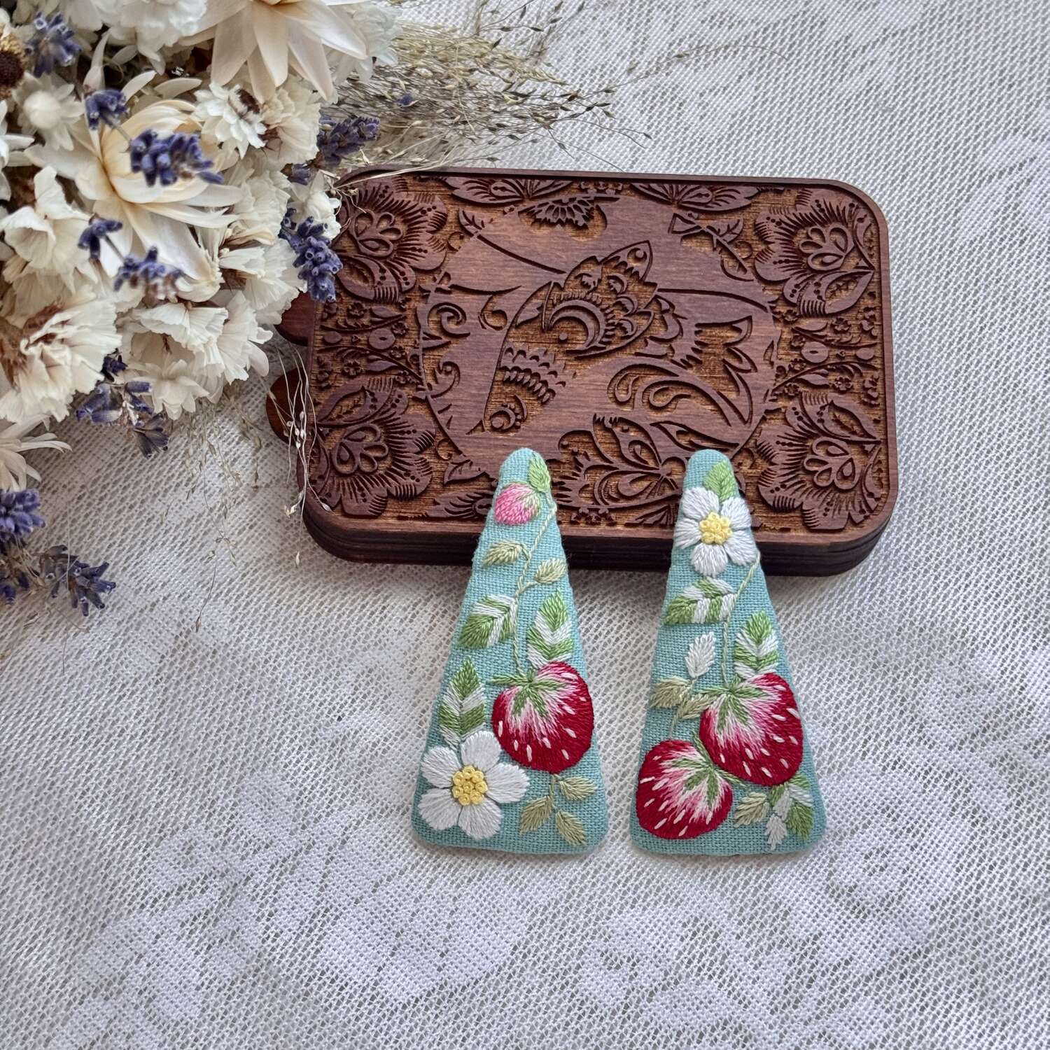 Käsin kirjotut hiuspinnit, metsämansikka ja kukka -aiheinen kuvio kankaalla