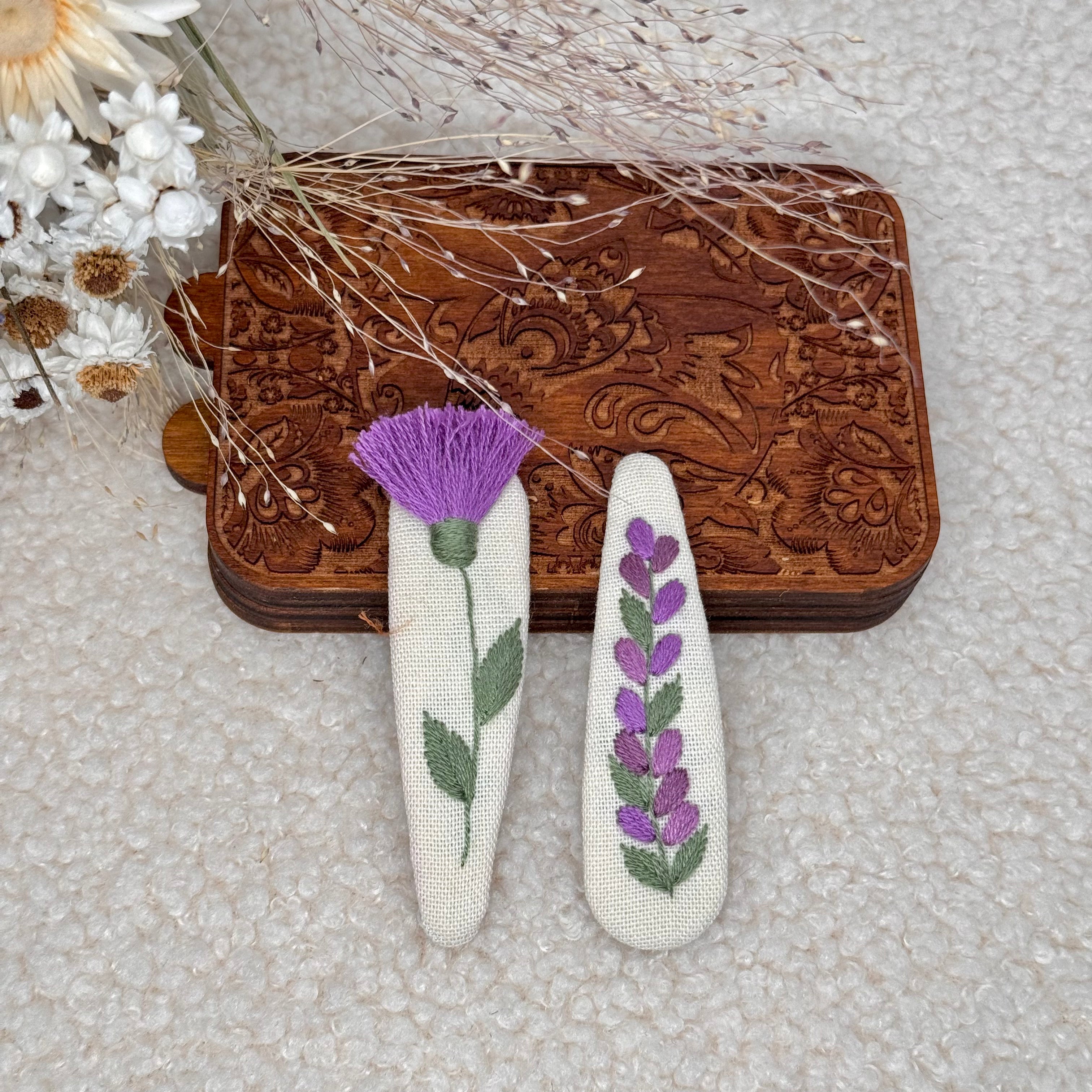 Käsin kirjotut hiuspinnit, mustakaunokki-aiheinen kuvio kankaalla