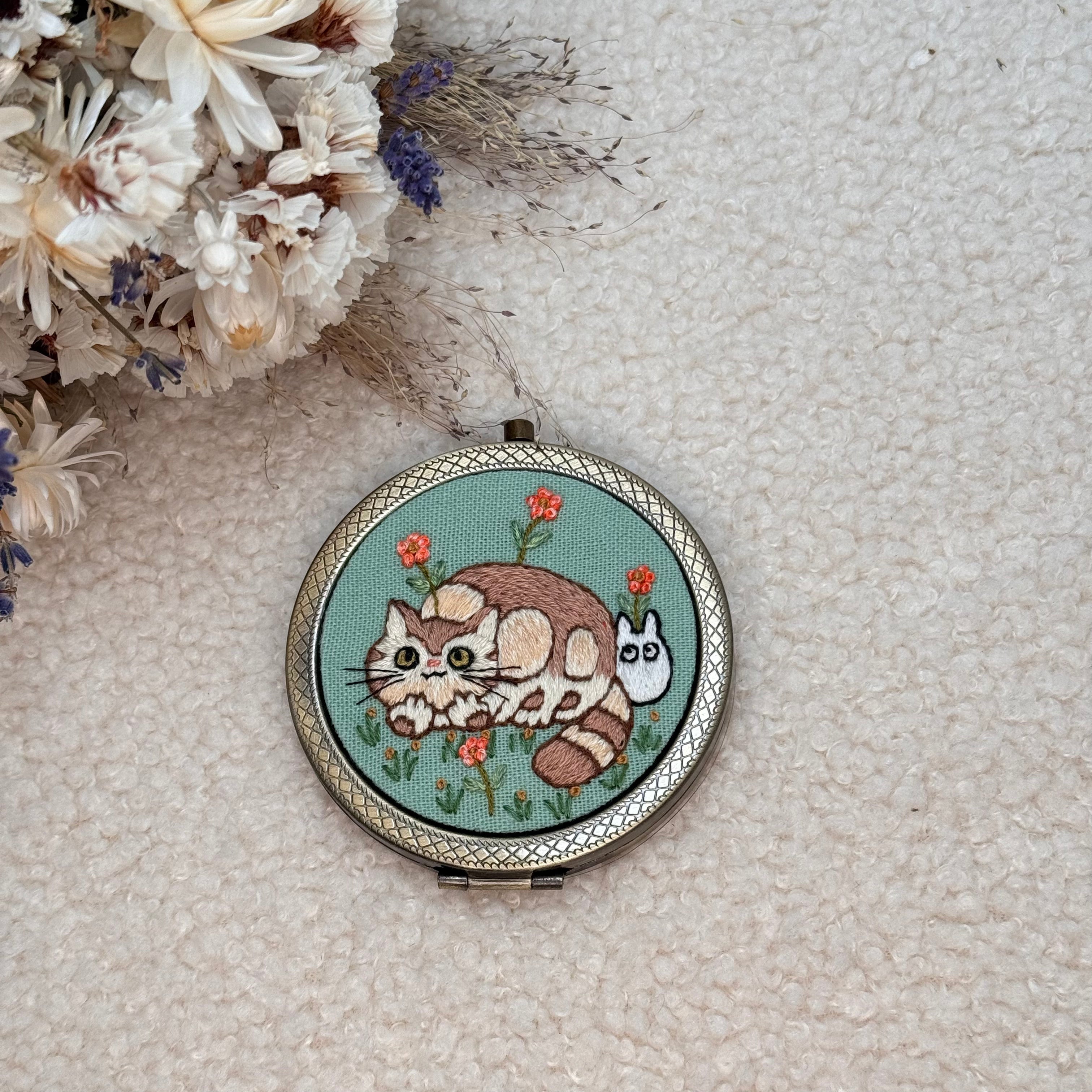 Käsin kirjottu taskupeili, Nekobasu-aiheinen kuvio kannessa