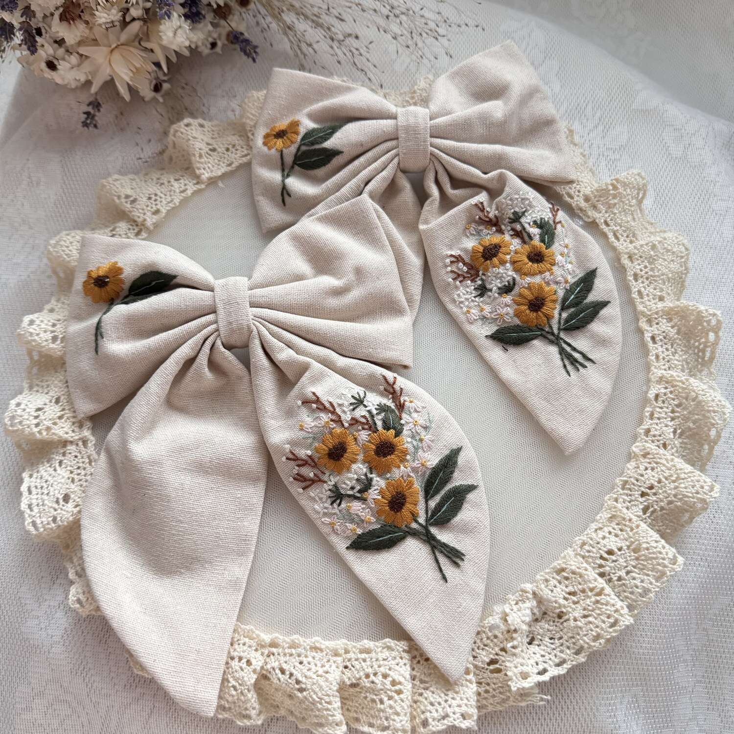 Käsin kirjottu hiusrusetti, niittyleinikki-aiheinen kuvio kankaalla