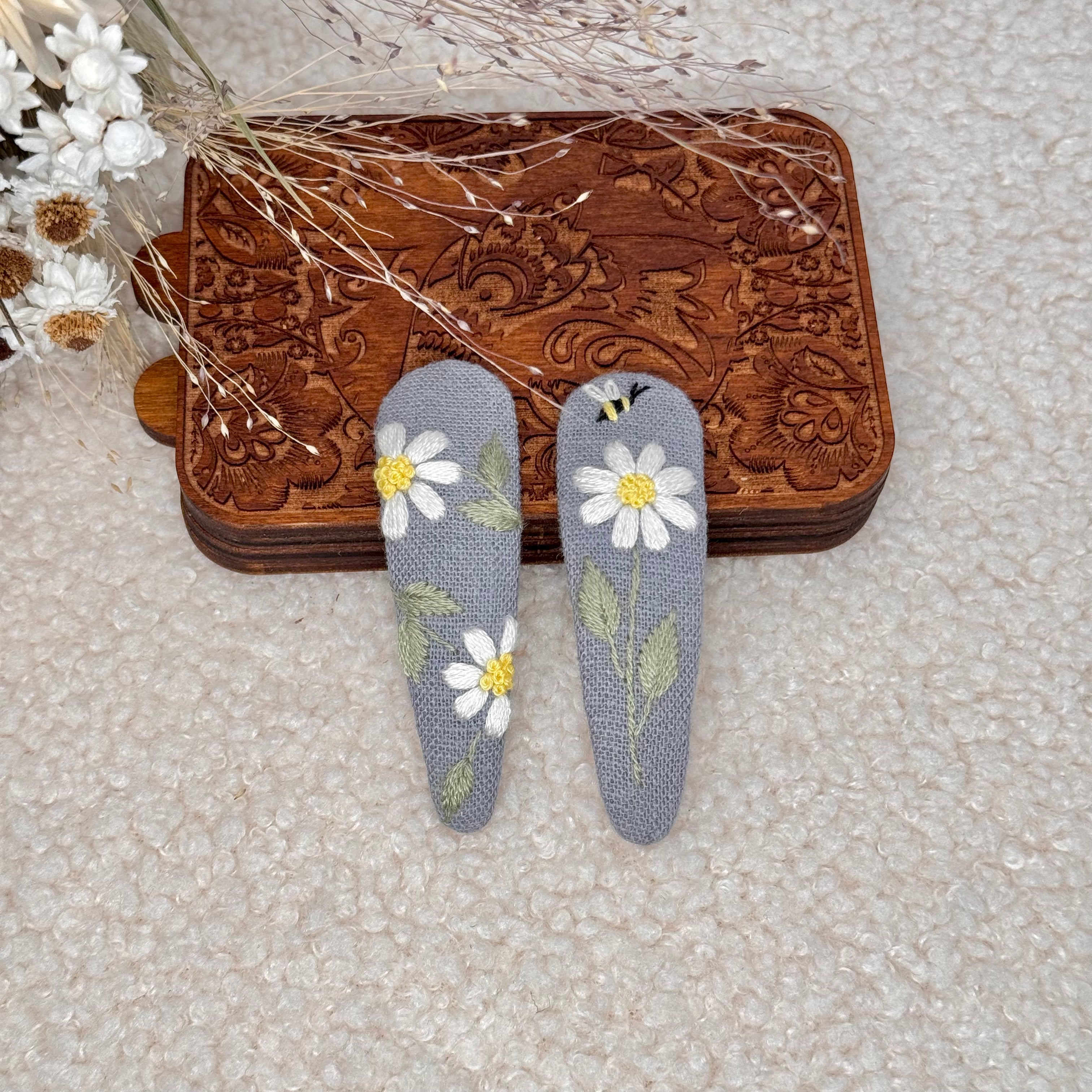 Käsin kirjotut hiuspinnit, päivänkakkara-aiheinen kuvio kankaalla