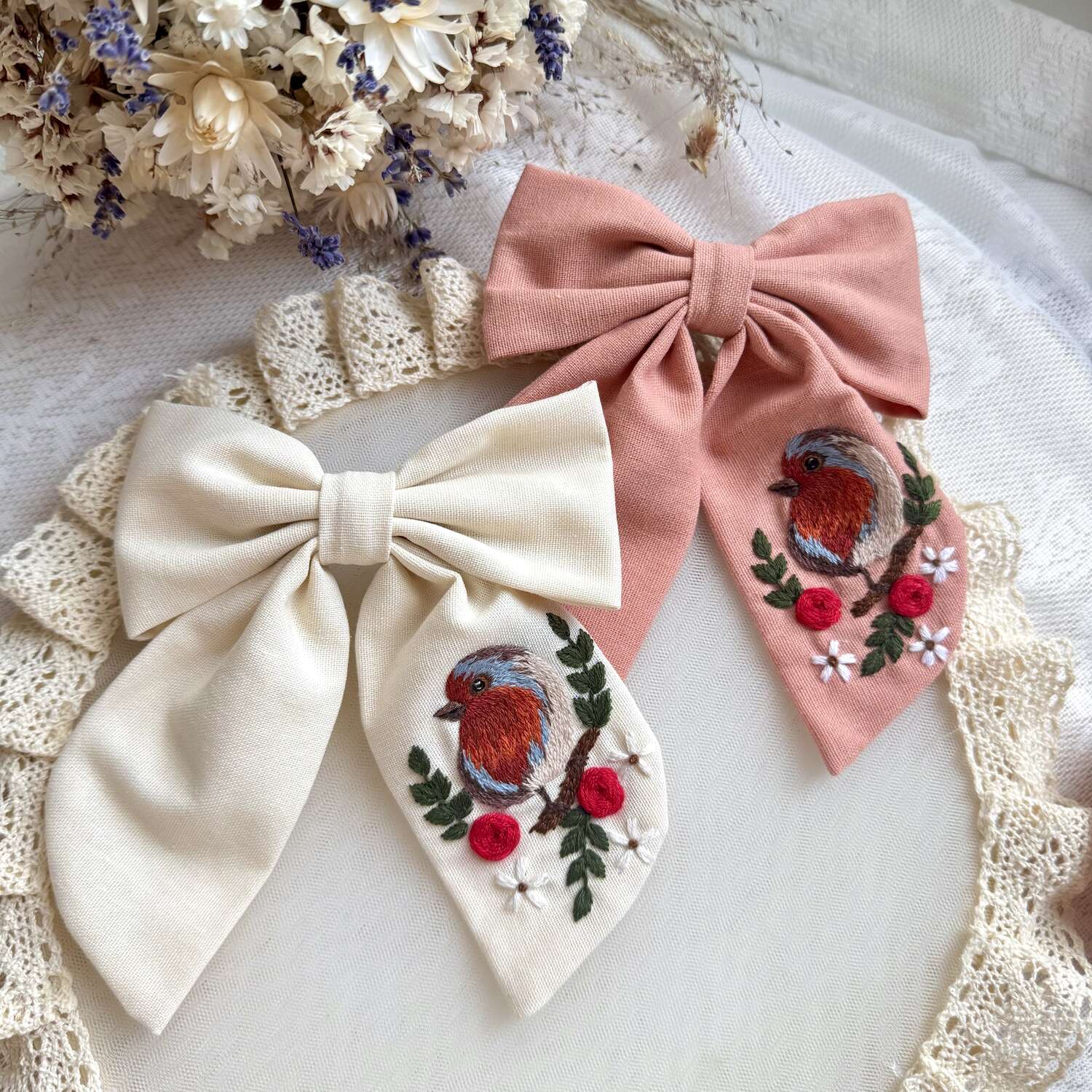 Käsin kirjottu hiusrusetti, peippo kukan oksalla -aiheinen kuvio kankaalla