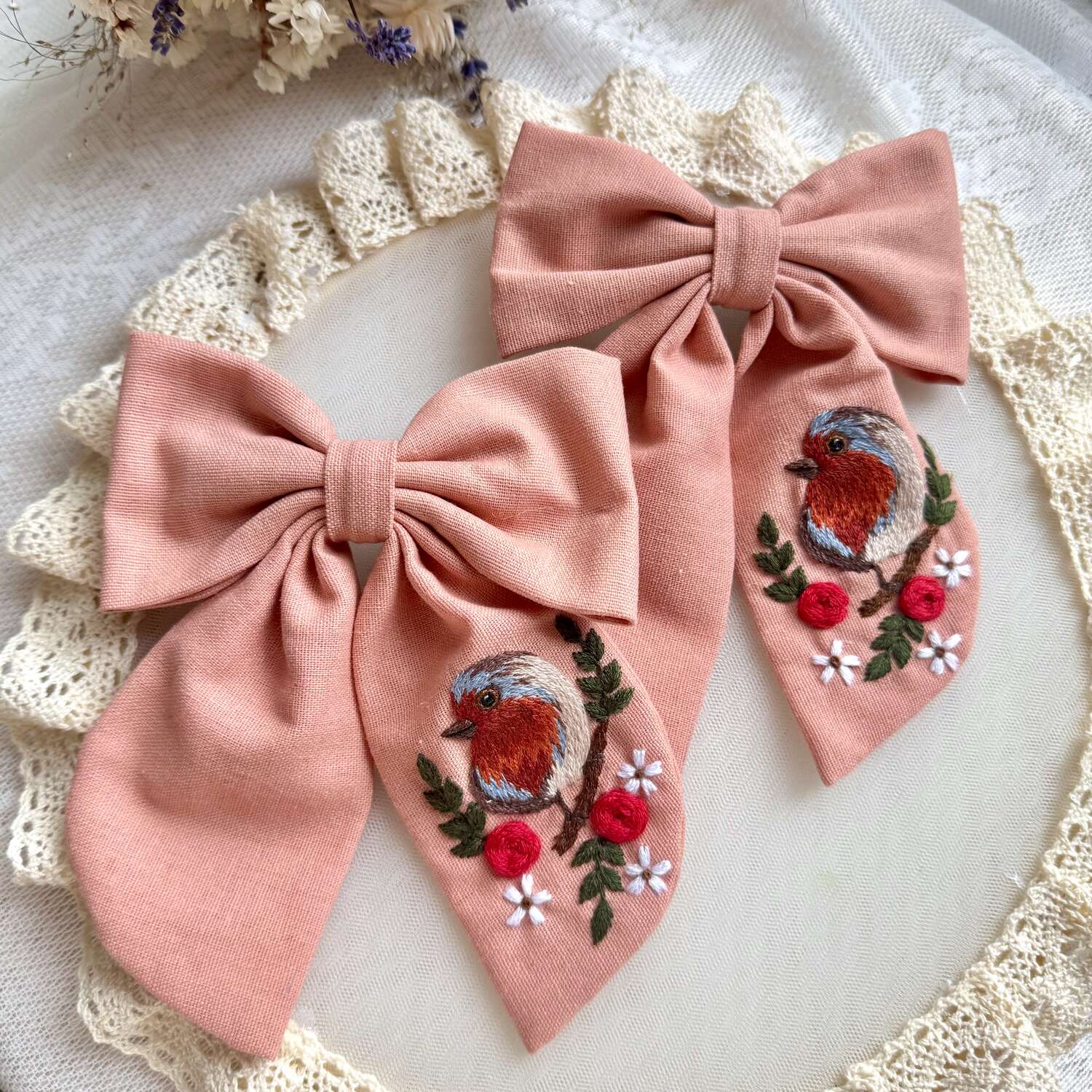 Käsin kirjottu hiusrusetti, peippo kukan oksalla -aiheinen kuvio kankaalla