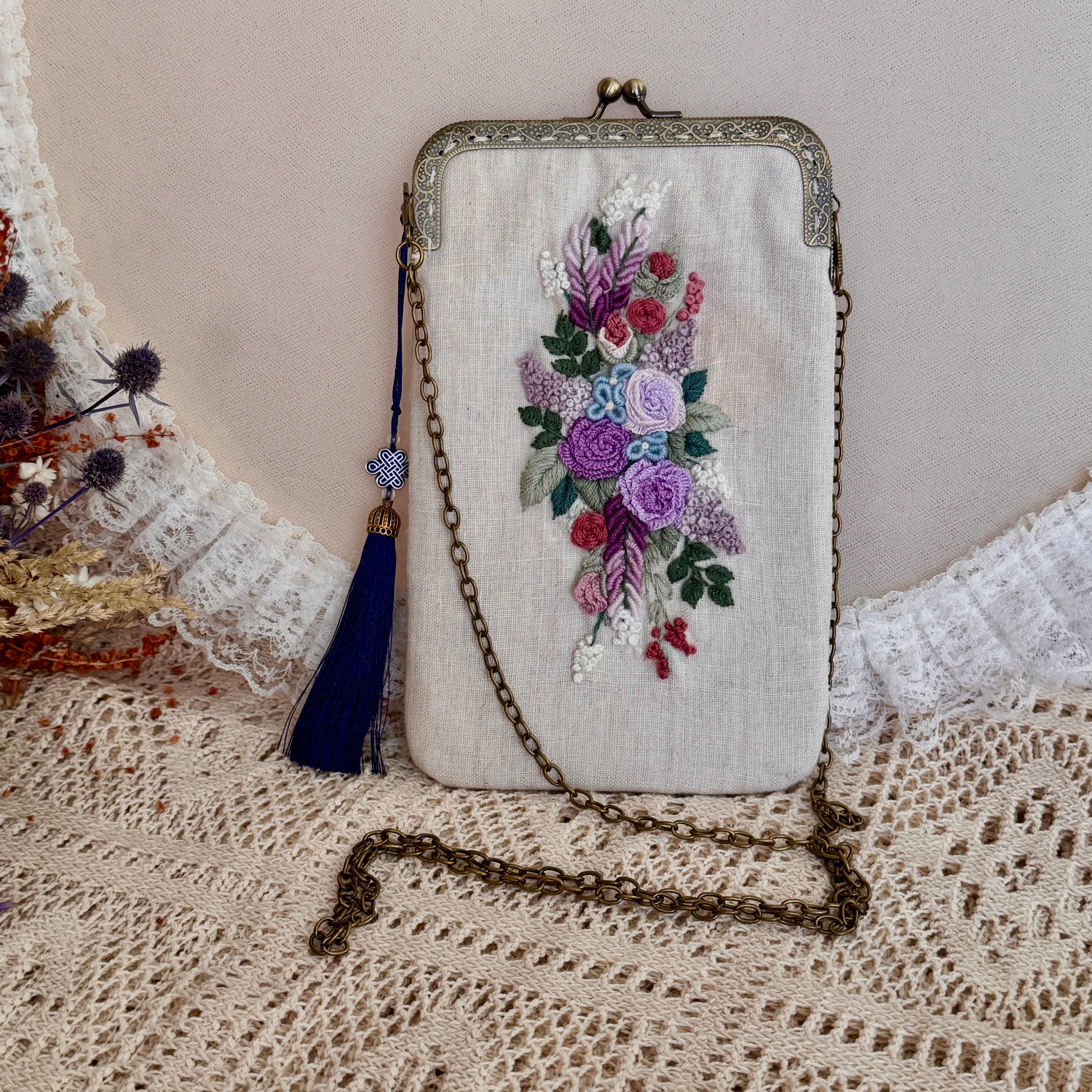 Käsin kirjottu puhelinlaukku, kukkakimppu-aiheinen kuvio kankaalla