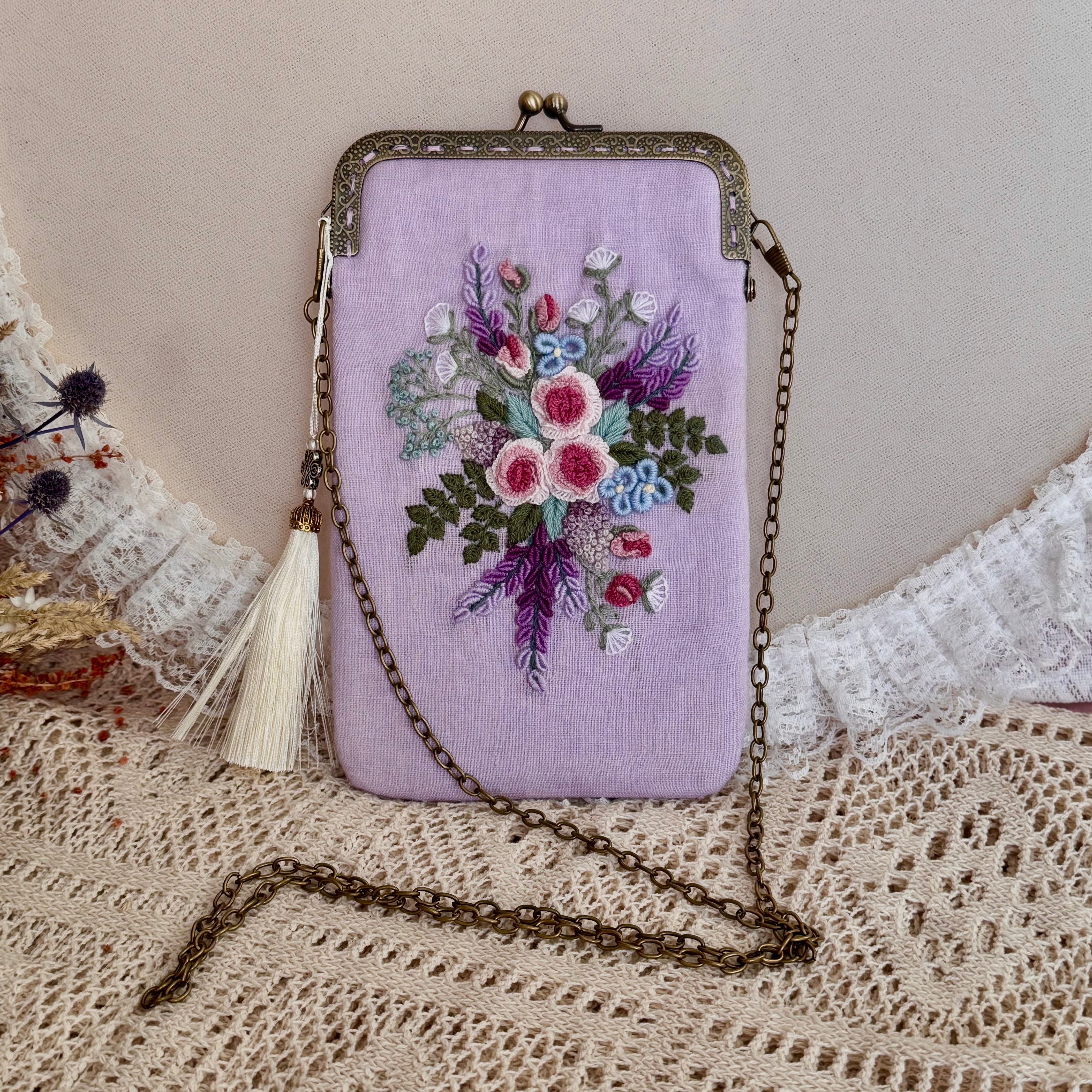 Käsin kirjottu puhelinlaukku, ruusu ja laventeli -aiheinen kuvio kankaalla
