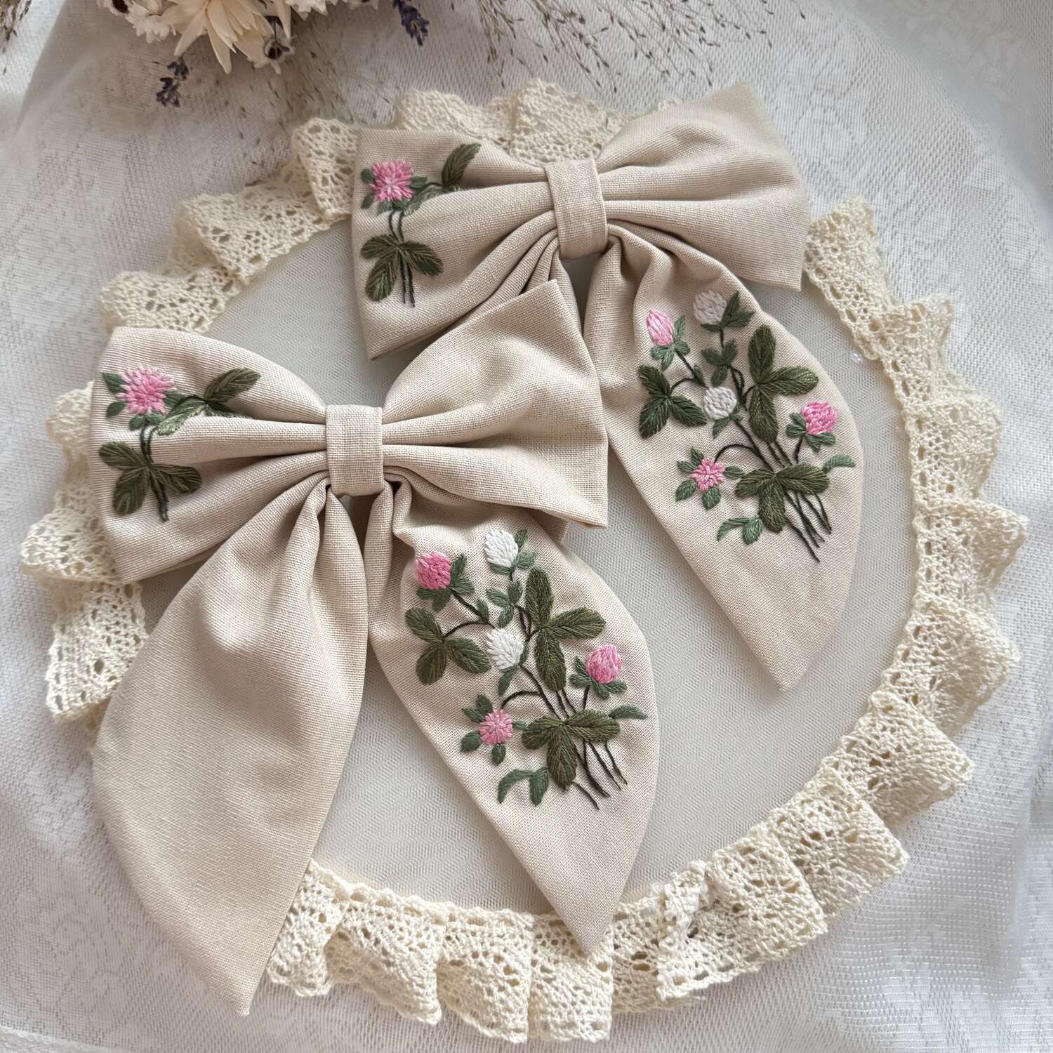 Käsin kirjottu hiusrusetti, puna-apila-aiheinen kuvio kankaalla