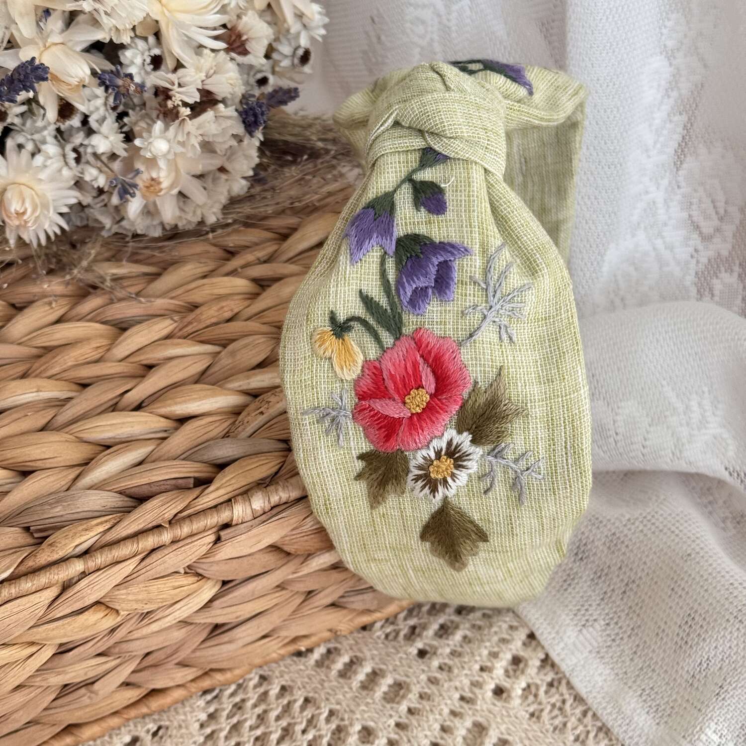 Käsin kirjottu turbaanipanta, ruusu ja kissankello -aiheinen kuvio kankaalla