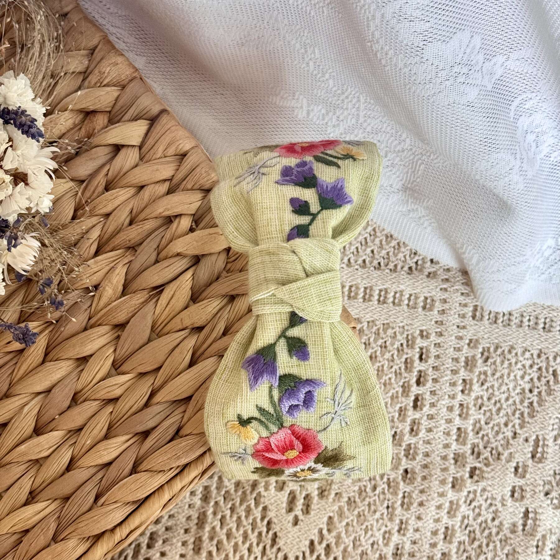 Käsin kirjottu turbaanipanta, ruusu ja kissankello -aiheinen kuvio kankaalla