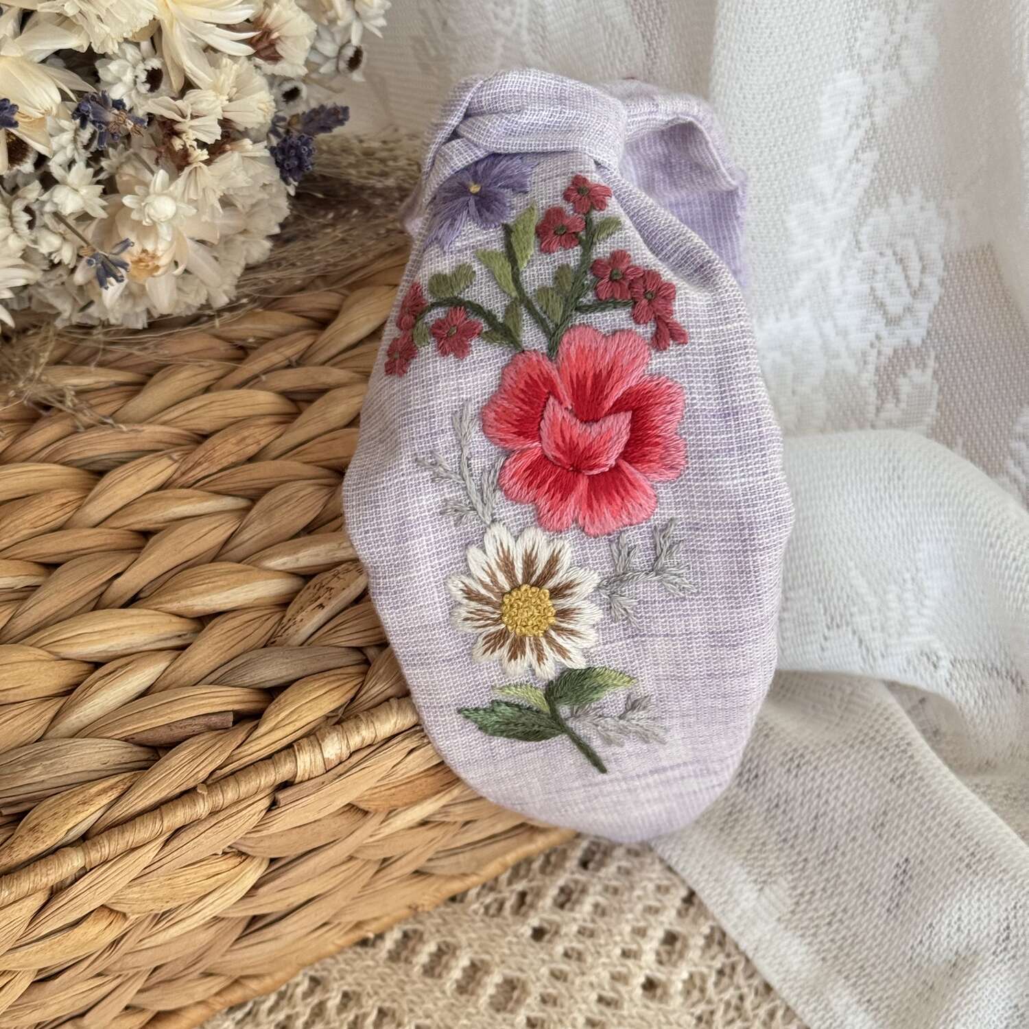 Käsin kirjottu turbaanipanta, ruusu ja valkovuokko -aiheinen kuvio kankaalla