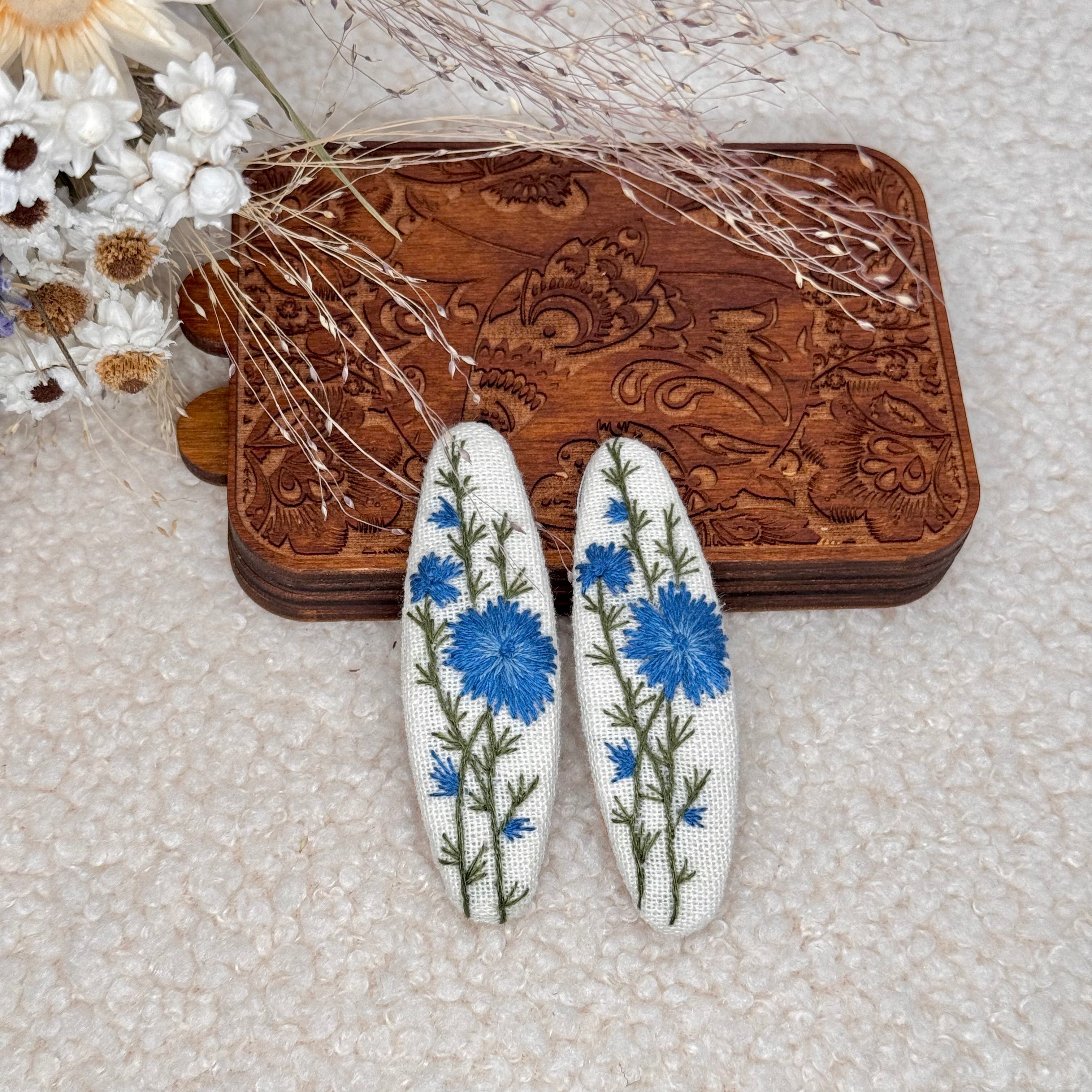 Käsin kirjotut hiuspinnit, sikuri-aiheinen kuvio kankaalla