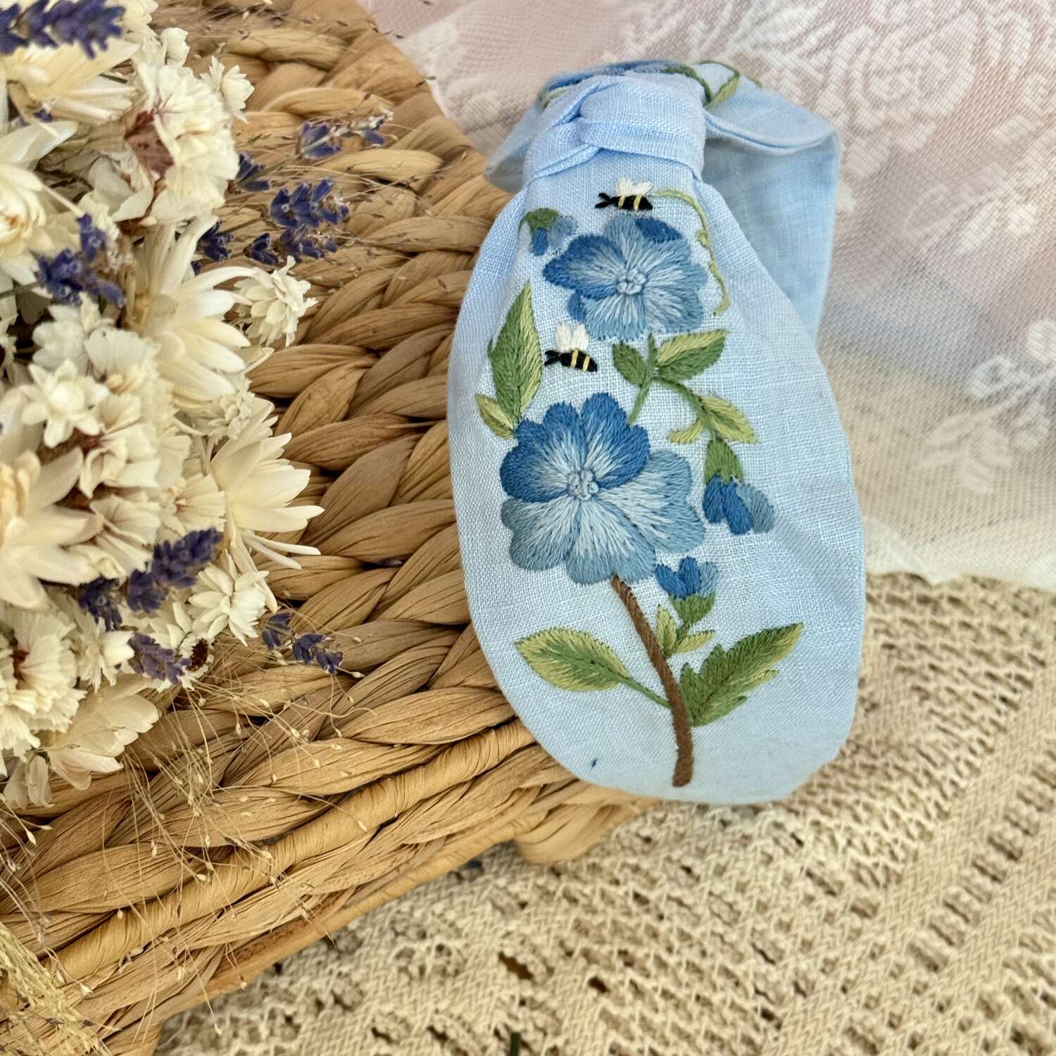 Käsin kirjottu turbaanipanta, sininen orvokki -aiheinen kuvio kankaalla