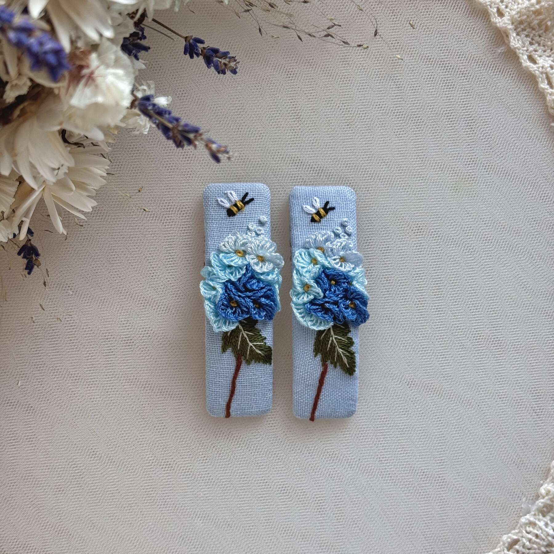 Käsin kirjotut hiuspinnit, sininen hortensia ja mehiläinen -aiheinen kuvio kankaalla