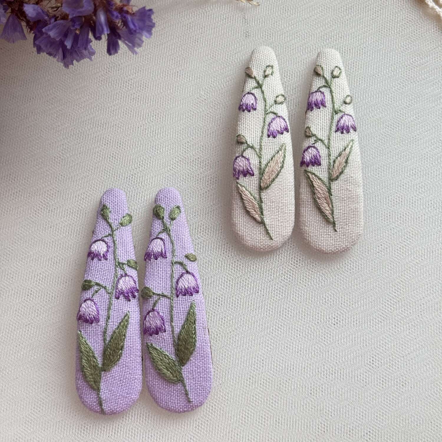 Käsin kirjotut hiuspinnit, vanamo-aiheinen kuvio kankaalla