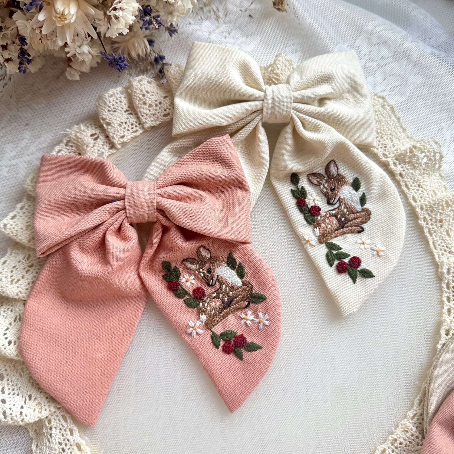 Käsin kirjottu hiusrusetti, vasa kukkapensaassa -aiheinen kuvio kankaalla