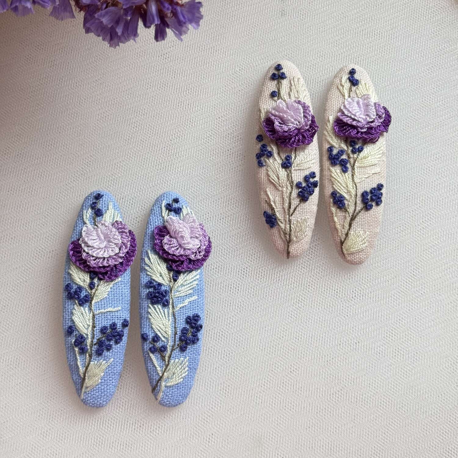 Käsin kirjotut hiuspinnit, violetti ruusu ja mustikka -aiheinen kuvio kankaalla