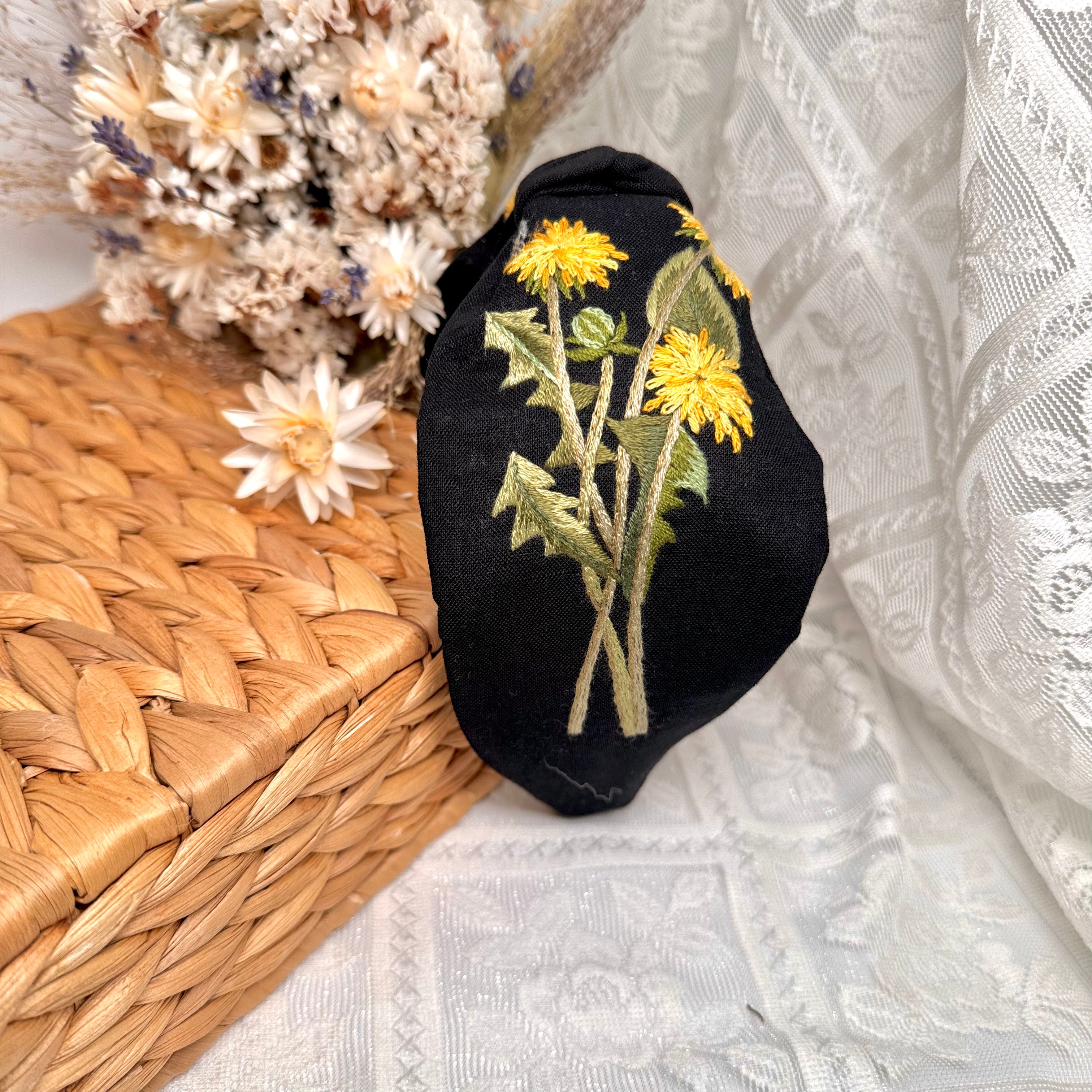 Käsin kirjottu turbaanipanta, voikukka-aiheinen kuvio kankaalla