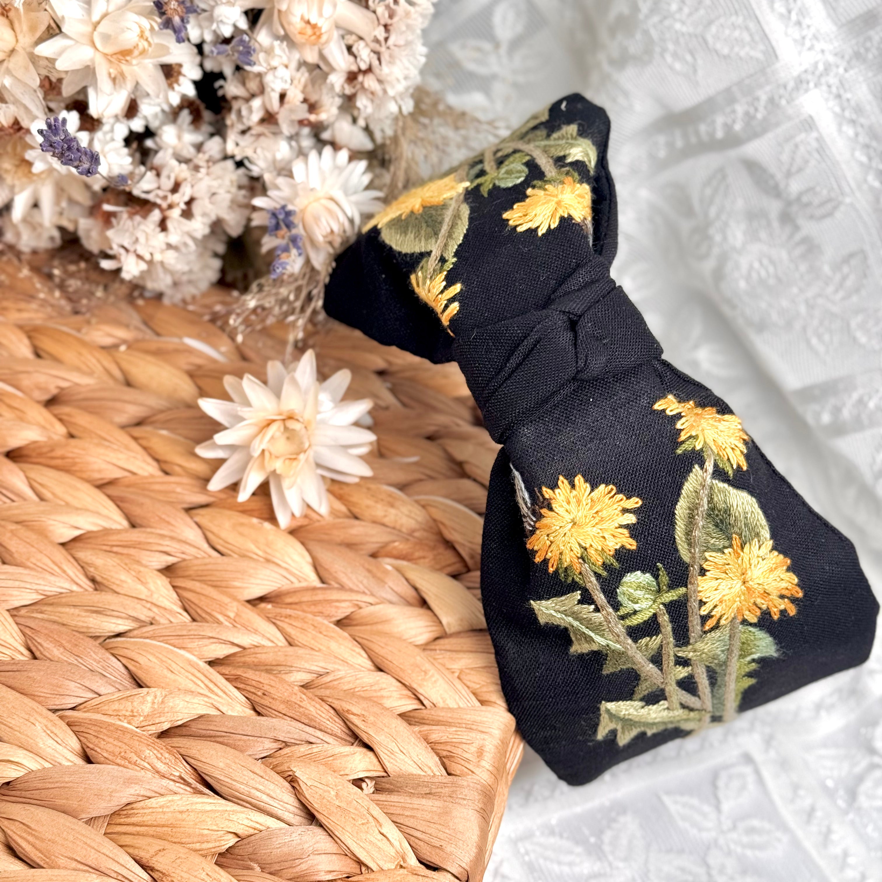 Käsin kirjottu turbaanipanta, voikukka-aiheinen kuvio kankaalla